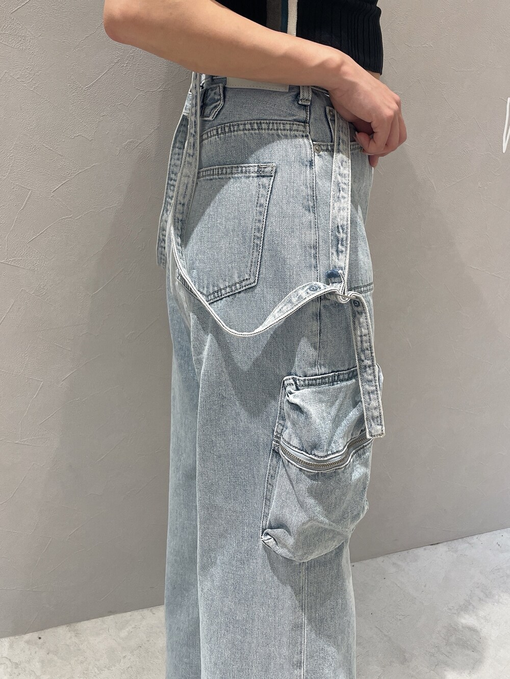 ブラック系のニット/セーター、ブルー系のデニムパンツ、ホワイト系のサンダルを着用したレディースの夏コーディネートの7枚目の写真