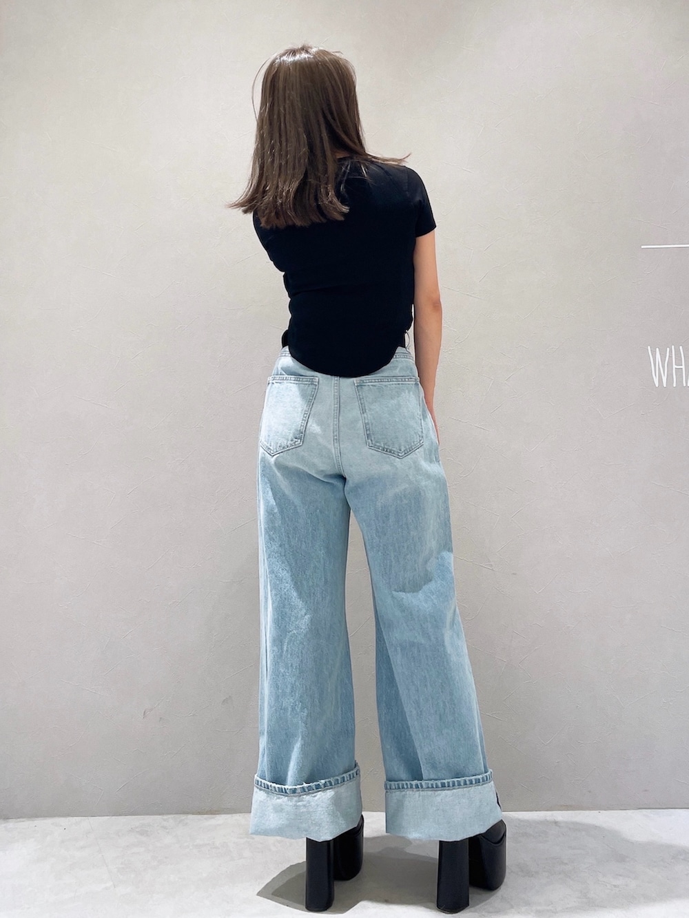 ブラック系のTシャツ/カットソー、ブルー系のデニムパンツ、ブラック系のサンダルを着用したレディースの夏コーディネートの3枚目の写真