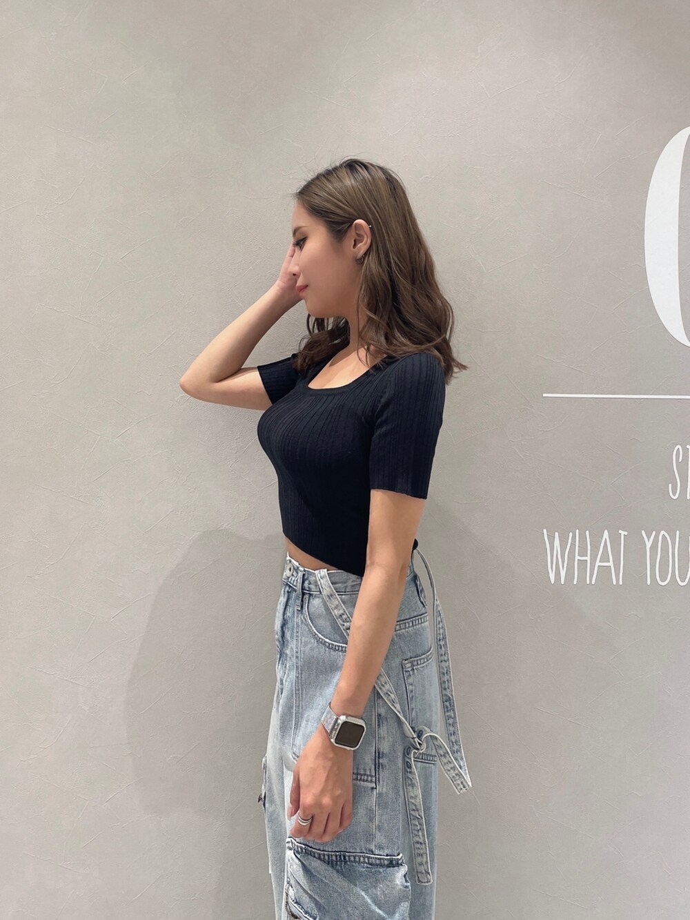 ブラック系のニット/セーター、ブルー系のデニムパンツ、ホワイト系のサンダルを着用したレディースの夏コーディネートの5枚目の写真