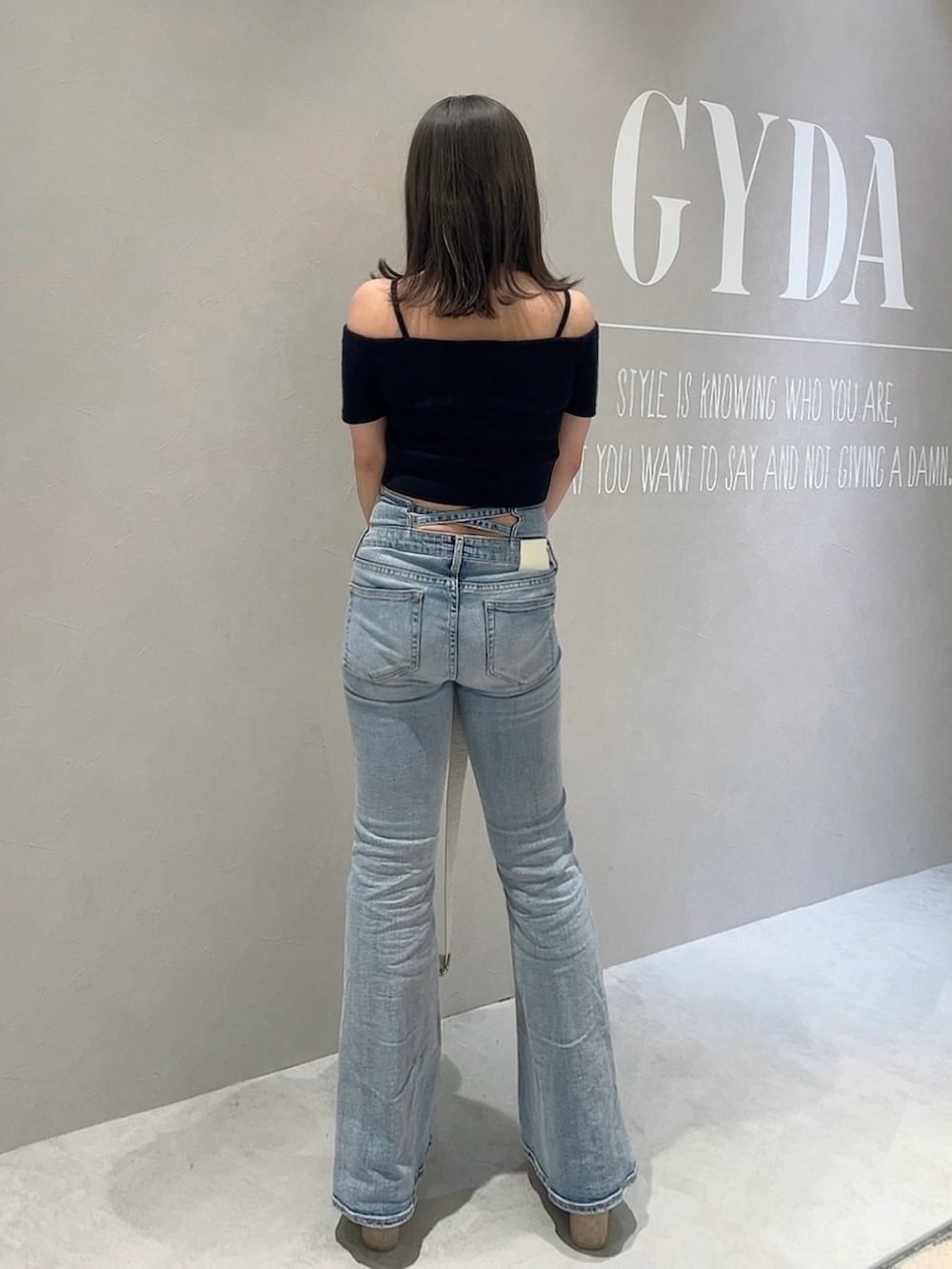 ブラック系のTシャツ/カットソー、ブルー系のデニムパンツ、ホワイト系のハンドバッグを着用したレディースの春コーディネートの3枚目の写真