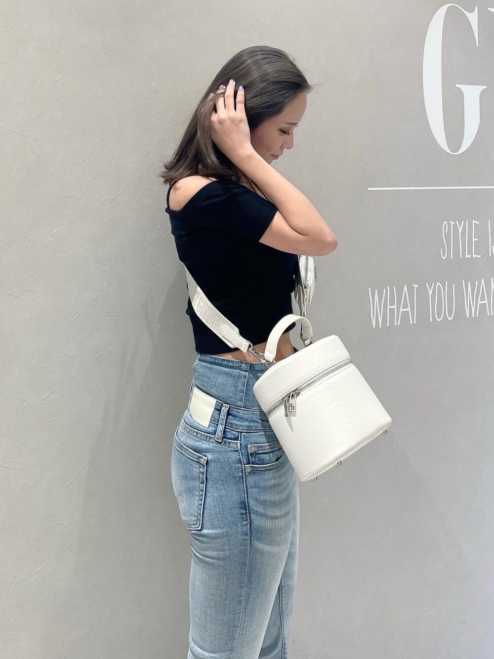 ブラック系のTシャツ/カットソー、ブルー系のデニムパンツ、ホワイト系のハンドバッグを着用したレディースの春コーディネートの5枚目の写真