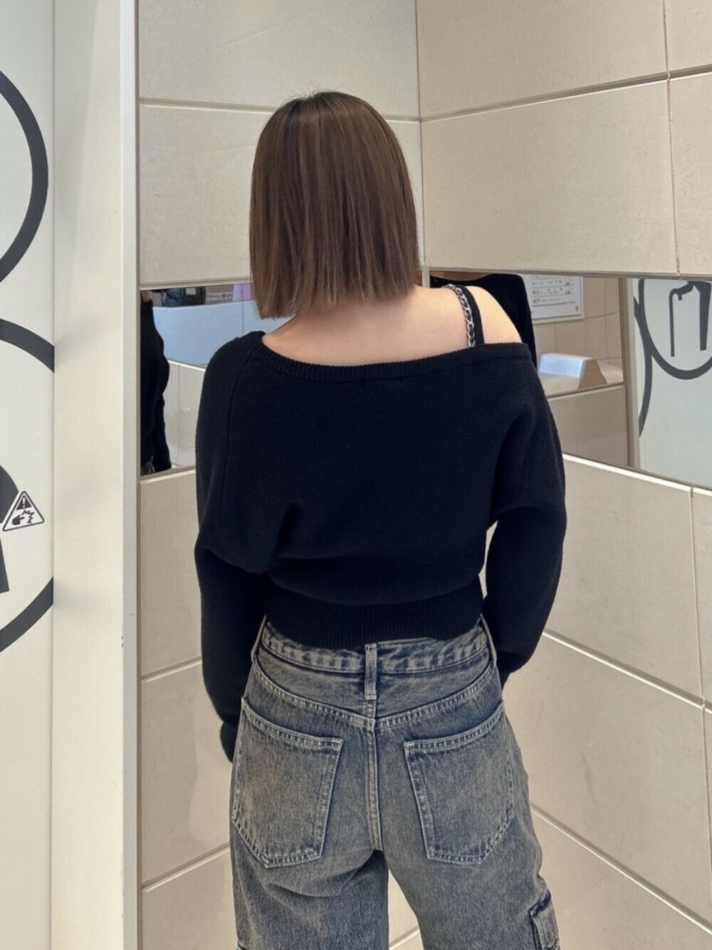 ブルー系のデニムパンツ、ブラック系のブーツ、ブラック系のニット/セーターを着用したレディースの秋コーディネートの6枚目の写真