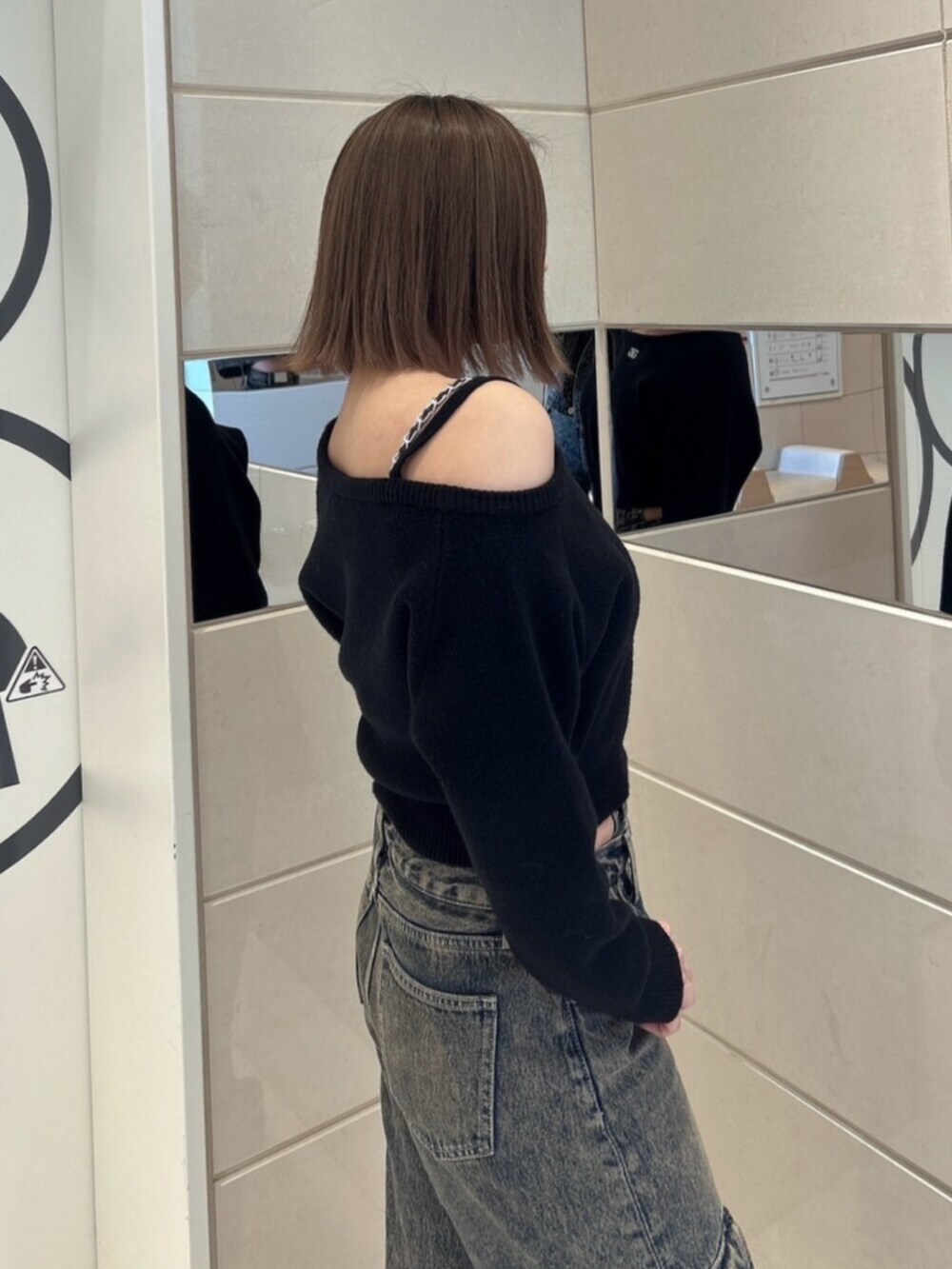 ブルー系のデニムパンツ、ブラック系のブーツ、ブラック系のニット/セーターを着用したレディースの秋コーディネートの5枚目の写真