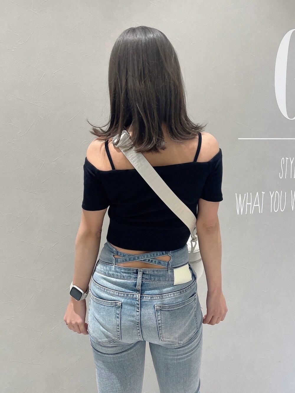 ブラック系のTシャツ/カットソー、ブルー系のデニムパンツ、ホワイト系のハンドバッグを着用したレディースの春コーディネートの6枚目の写真