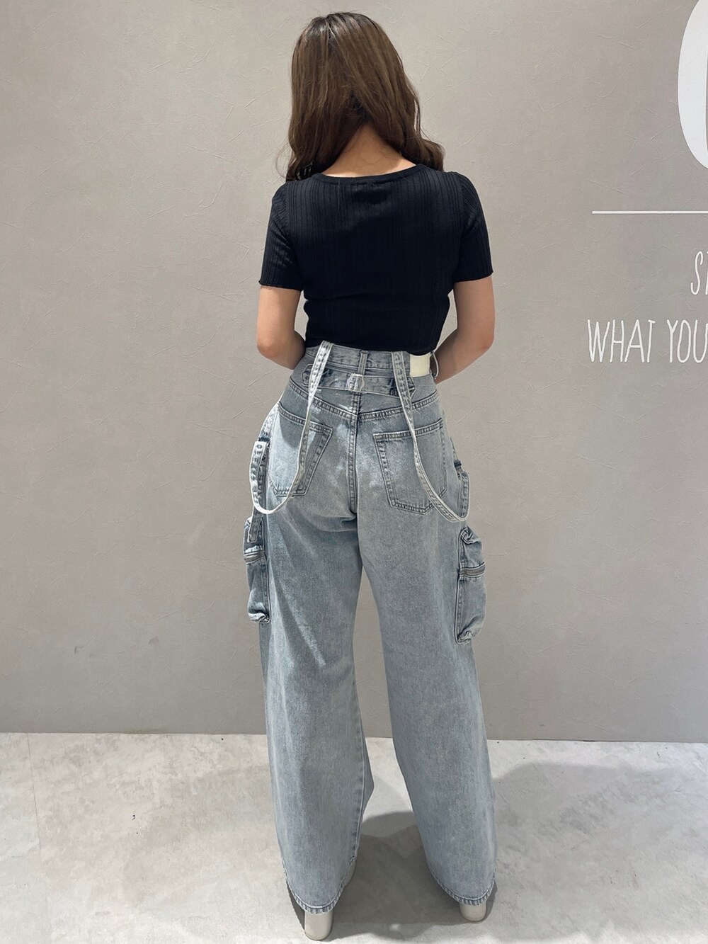 ブラック系のニット/セーター、ブルー系のデニムパンツ、ホワイト系のサンダルを着用したレディースの夏コーディネートの3枚目の写真