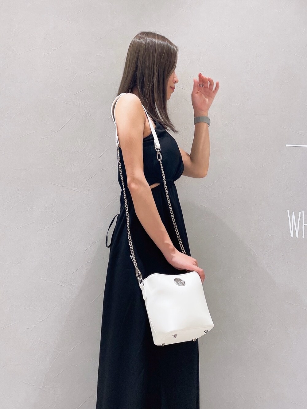 ブラック系のワンピース、ホワイト系のサンダル、ホワイト系のショルダーバッグを着用したレディースの夏コーディネートの6枚目の写真