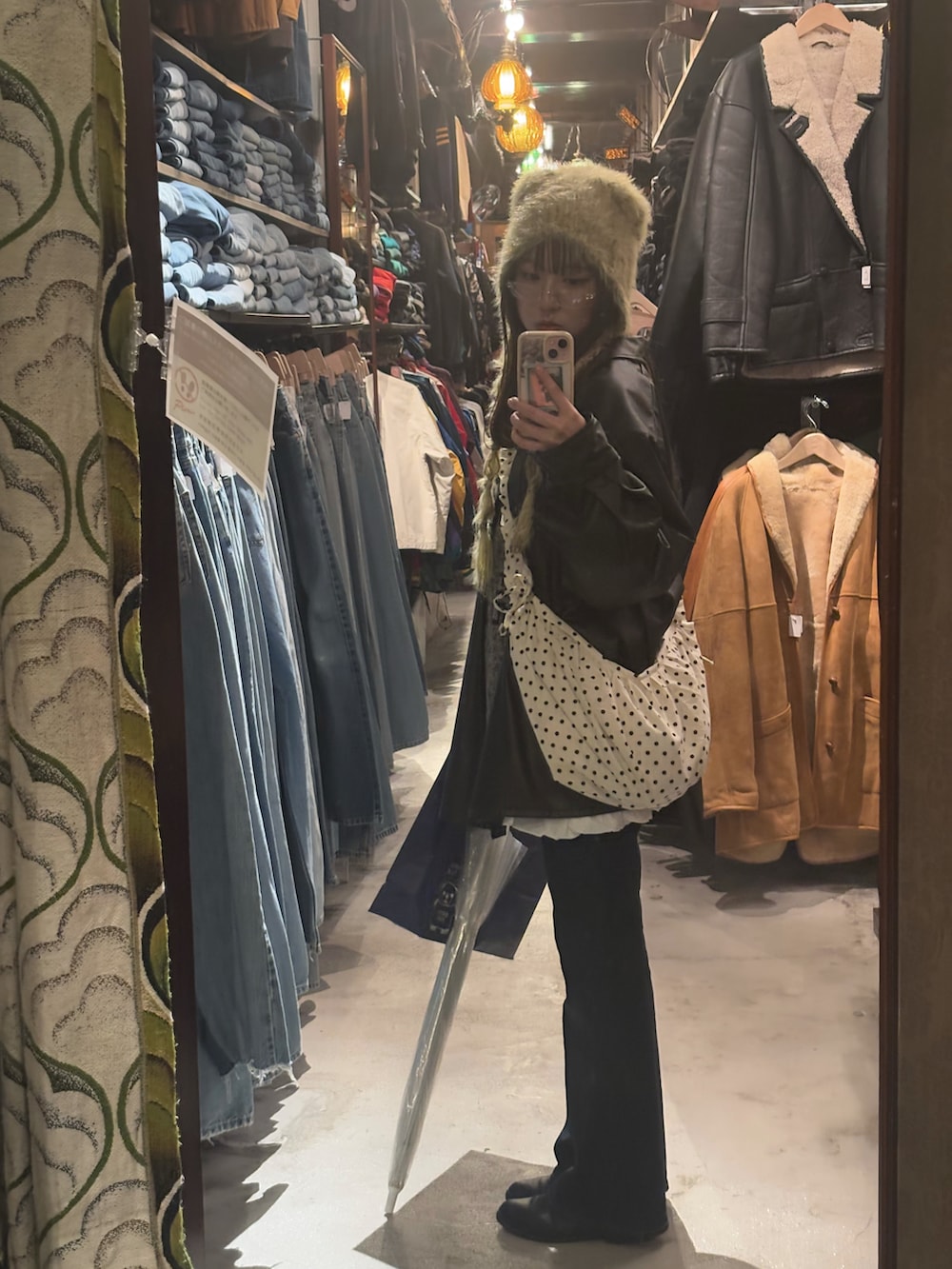 ブラウン系のジャケット/アウター、グレー系のニット/セーター、ホワイト系のスカートを着用したレディースの冬コーディネートの2枚目の写真