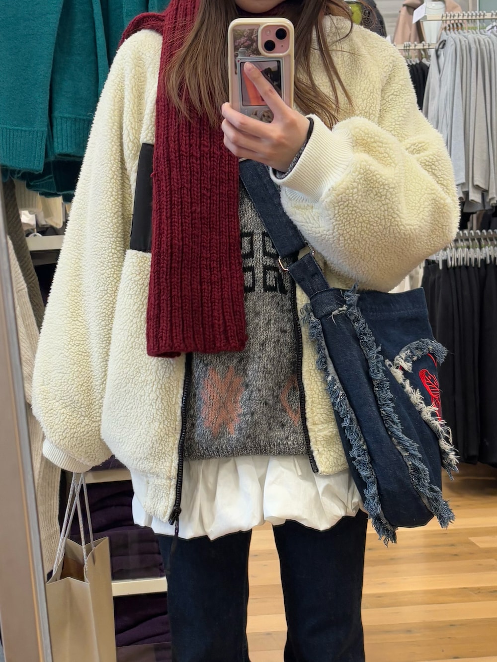 ブルー系のショルダーバッグ、ブルー系のデニムパンツ、ホワイト系のその他アウターを着用したレディースの冬コーディネートの2枚目の写真