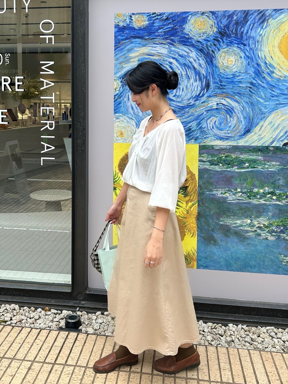 ベージュ系のスカート、ブラウン系のローファー、ホワイト系のシャツ/ブラウスを着用したレディースの秋コーディネートの2枚目の写真