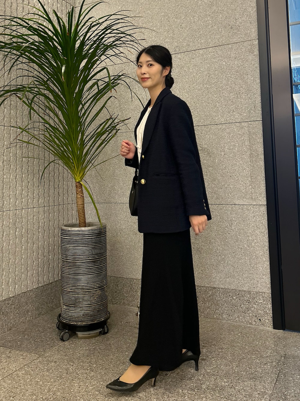 ホワイト系のシャツ/ブラウス、ブルー系のテーラードジャケット、ブラック系のパンプスを着用したレディースの冬コーディネートの2枚目の写真