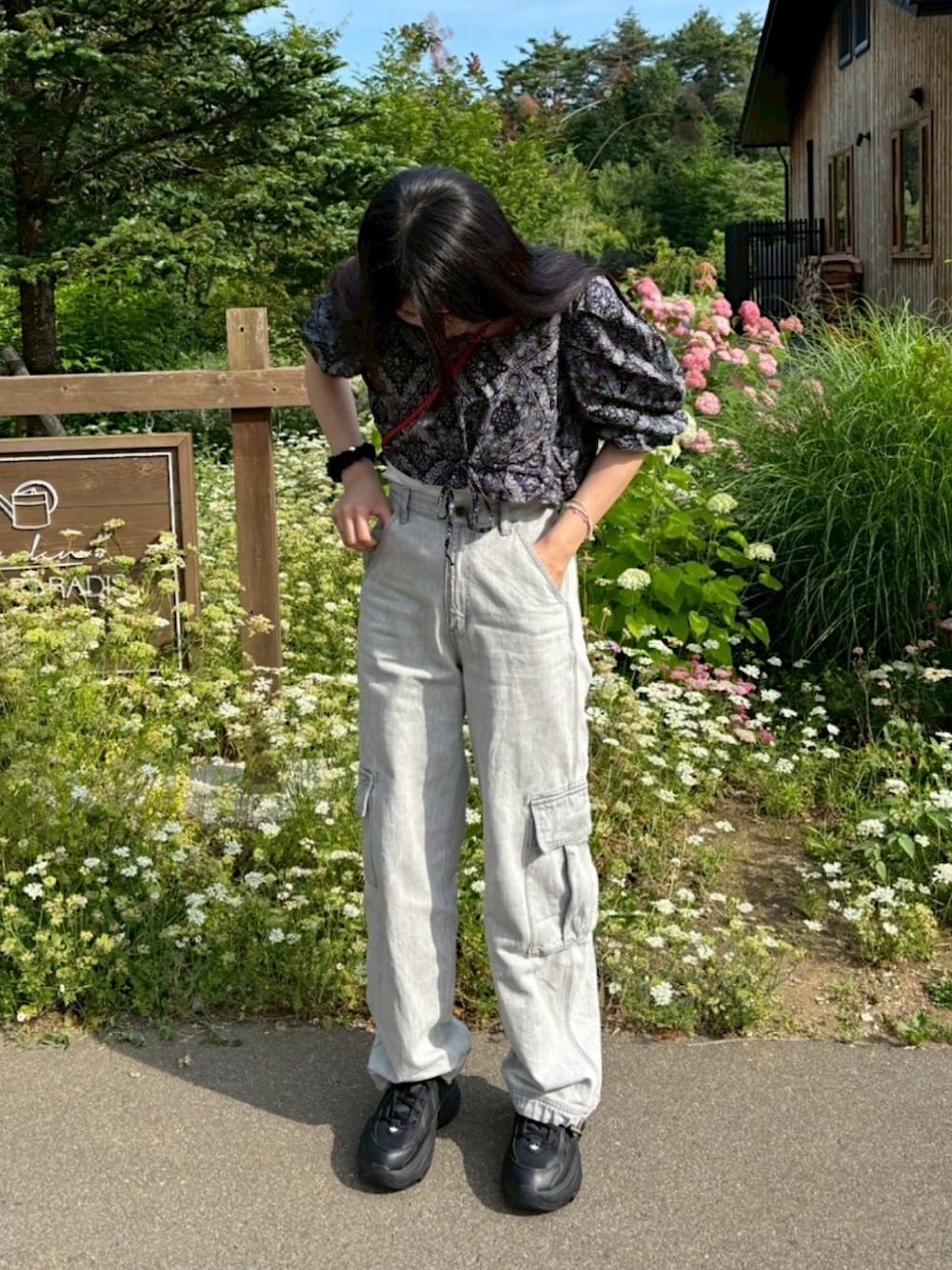 ブラック系のスニーカー、グレー系のカーゴパンツ、レッド系のショルダーバッグを着用したレディースの夏コーディネートの3枚目の写真