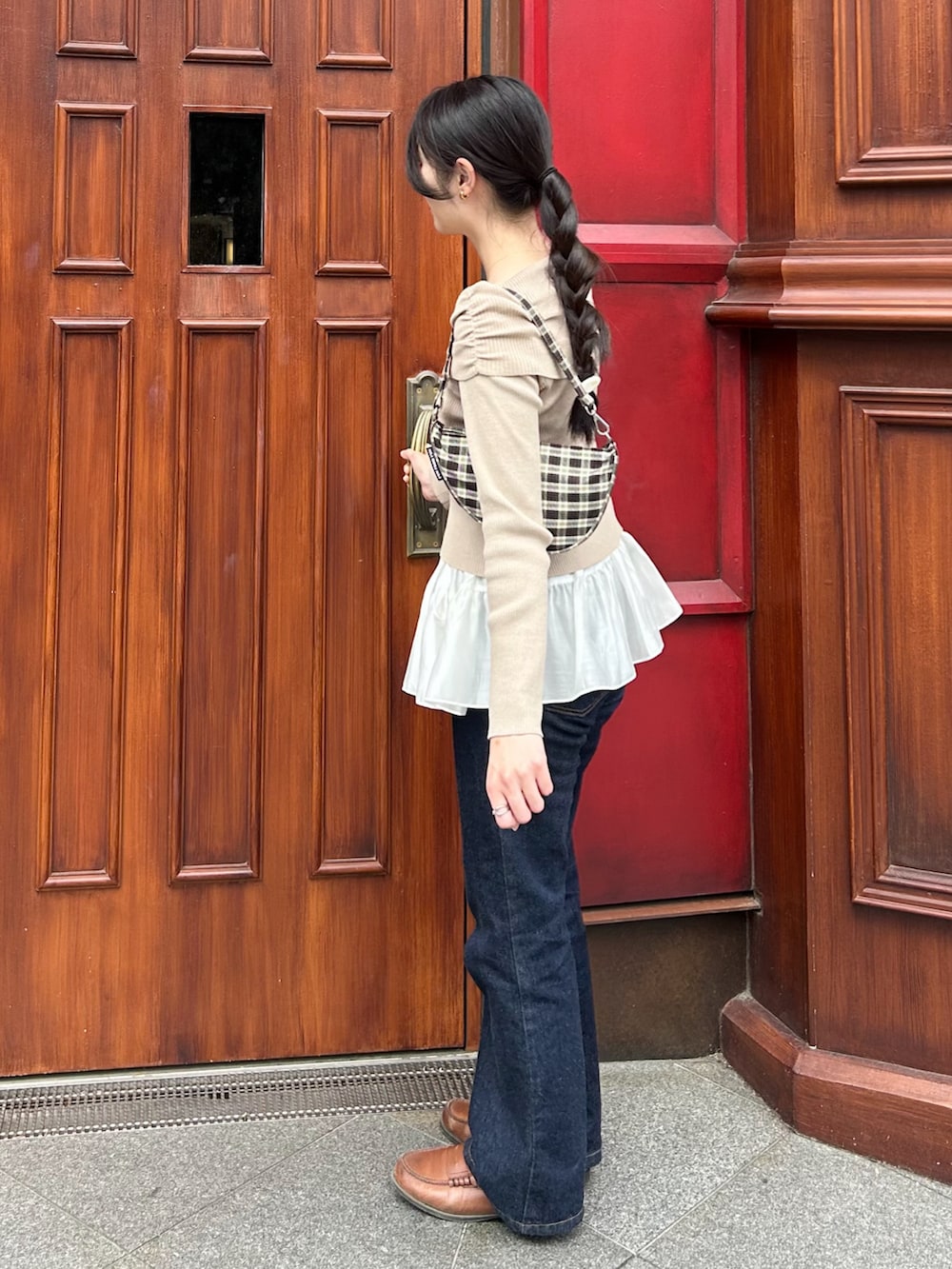 ブルー系のデニムパンツ、ホワイト系のスカート、ベージュ系のニット/セーターを着用したレディースの春コーディネートの4枚目の写真