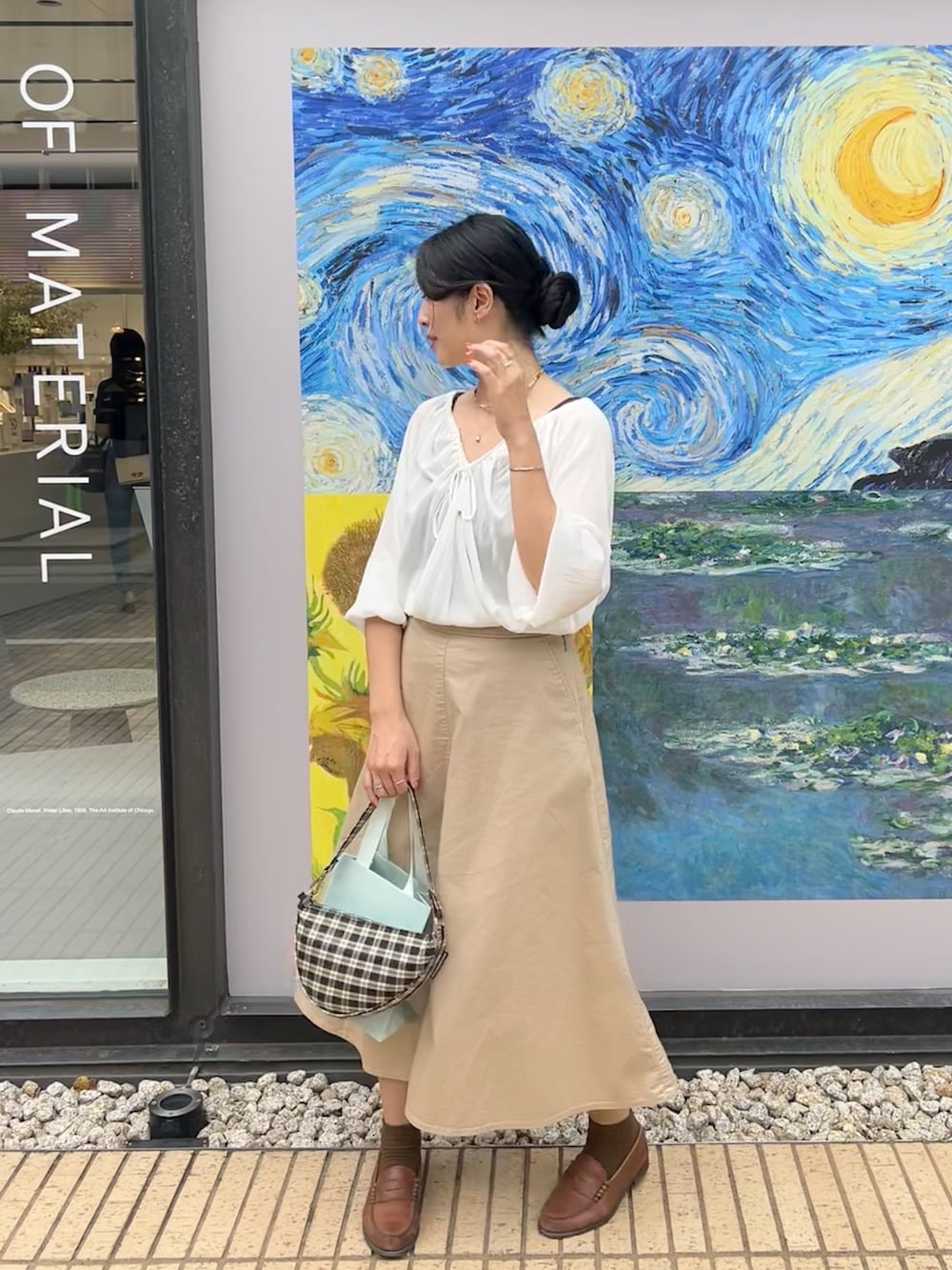 ベージュ系のスカート、ブラウン系のローファー、ホワイト系のシャツ/ブラウスを着用したレディースの秋コーディネートの3枚目の写真