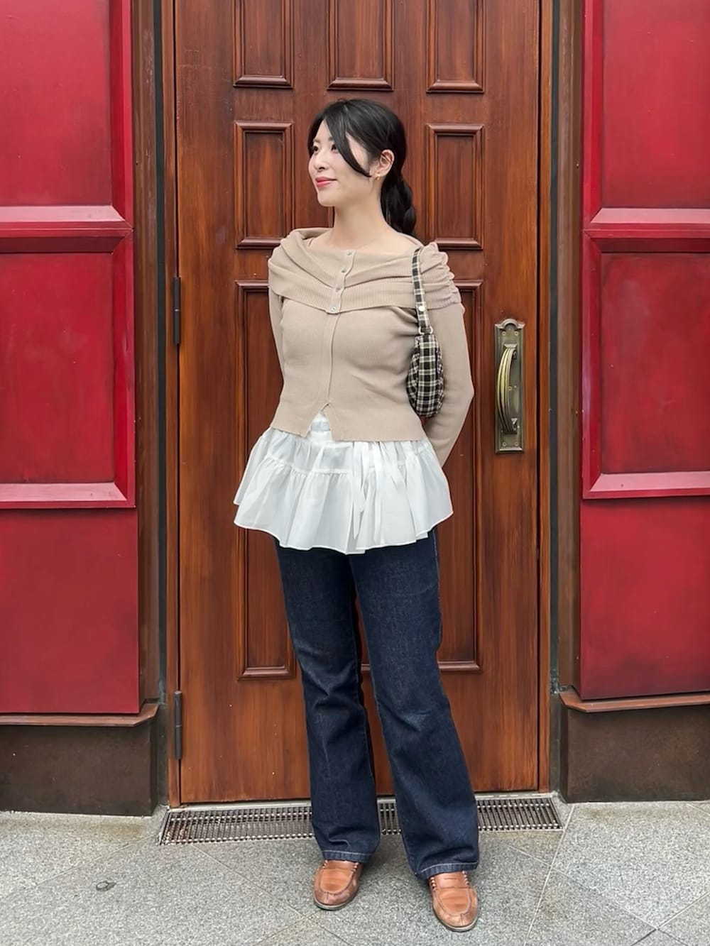 ブルー系のデニムパンツ、ホワイト系のスカート、ベージュ系のニット/セーターを着用したレディースの春コーディネートの3枚目の写真