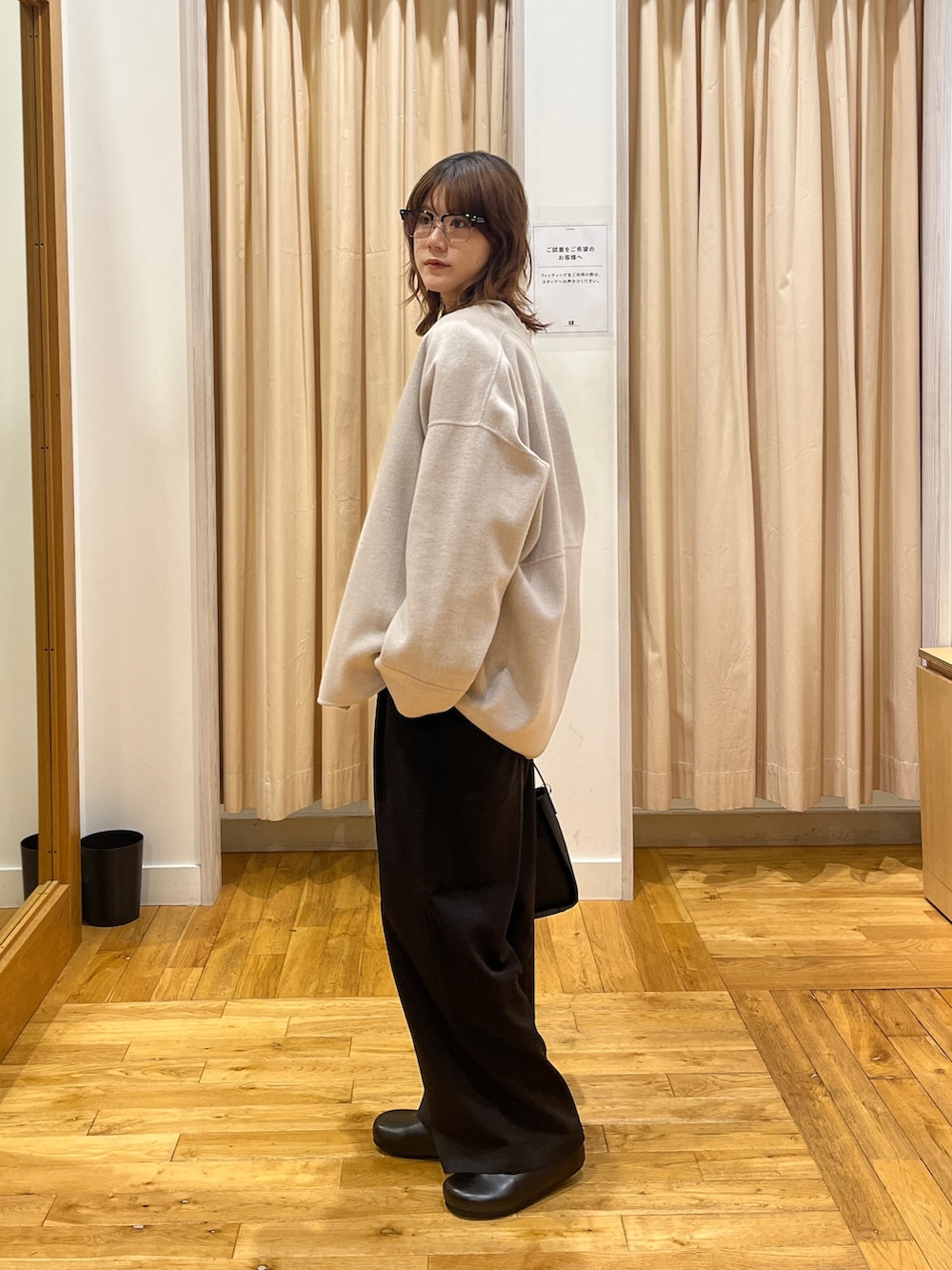 ブラウン系のカーディガン/ボレロ、ホワイト系のTシャツ/カットソー、ブラック系のハンドバッグを着用したレディースの秋コーディネートの3枚目の写真