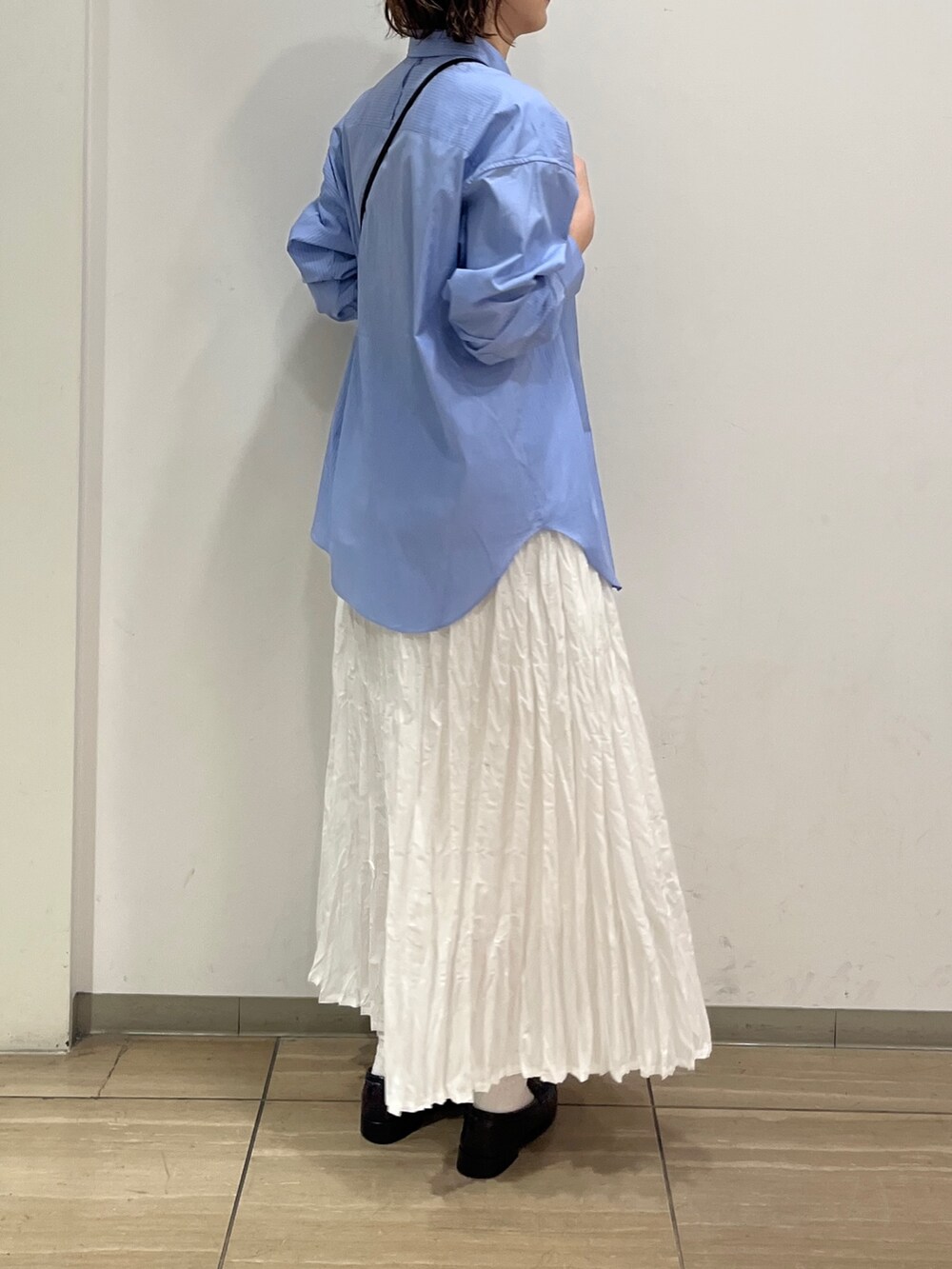 ホワイト系のスカート、ブルー系のシャツ/ブラウス、ブラック系のショルダーバッグを着用したレディースの冬コーディネートの5枚目の写真