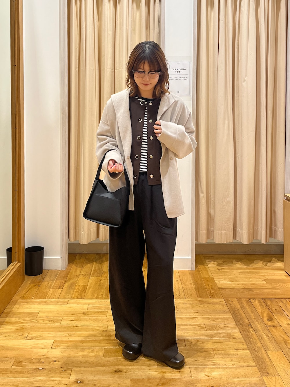 ブラウン系のカーディガン/ボレロ、ホワイト系のTシャツ/カットソー、ブラック系のハンドバッグを着用したレディースの秋コーディネートの2枚目の写真