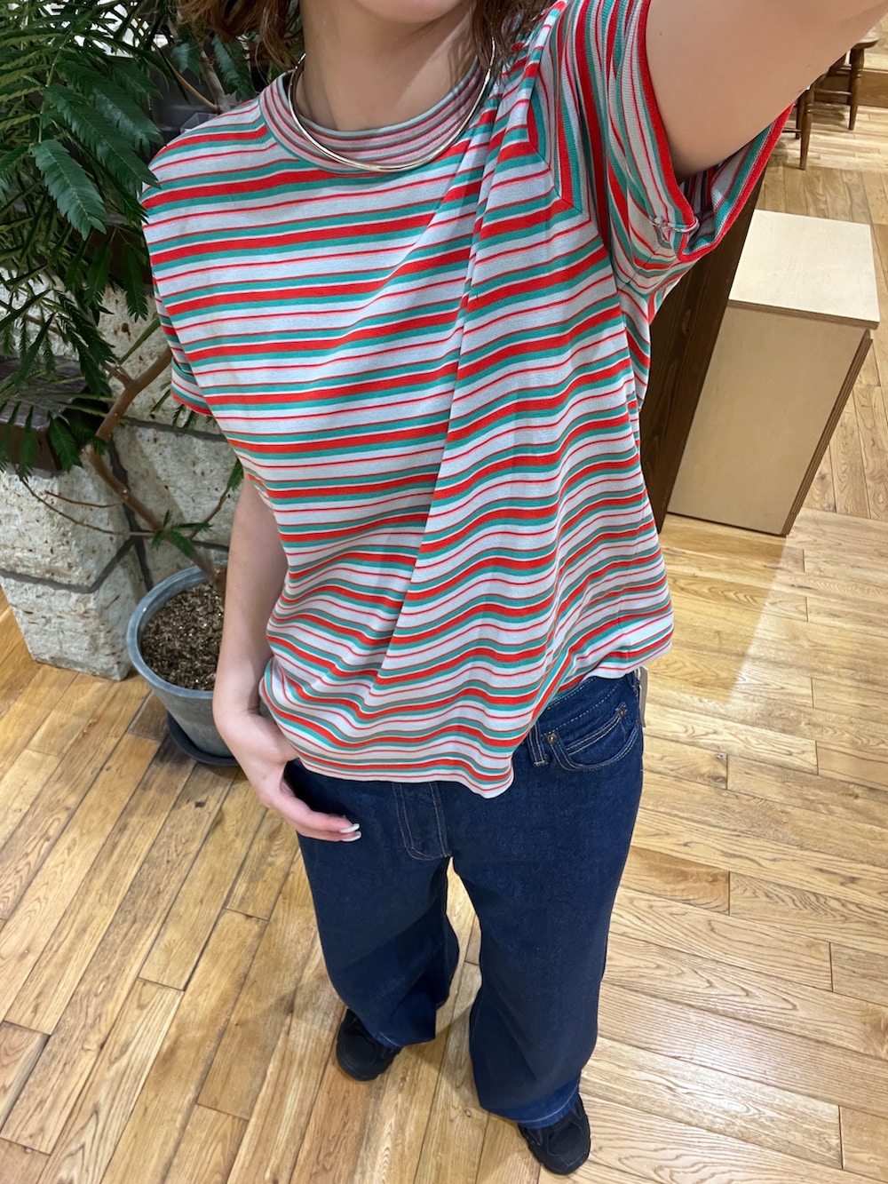 レッド系のTシャツ/カットソー、ブルー系のデニムパンツを着用したレディースの夏コーディネートの3枚目の写真