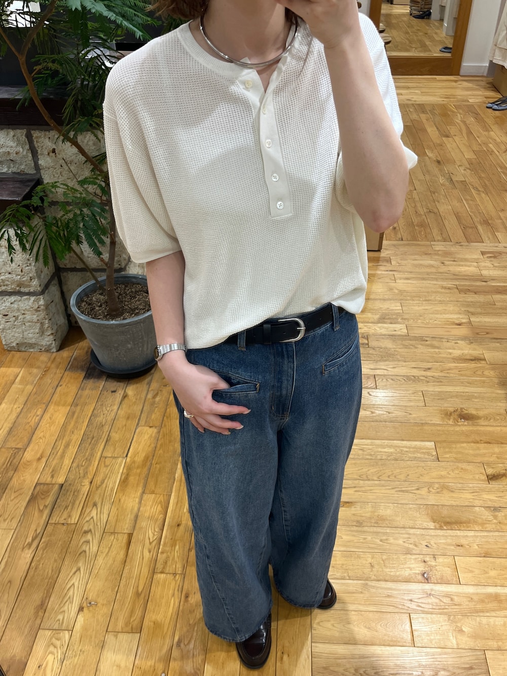 ブルー系のデニムパンツ、ホワイト系のニット/セーター、グリーン系のトートバッグを着用したレディースの春コーディネートの4枚目の写真
