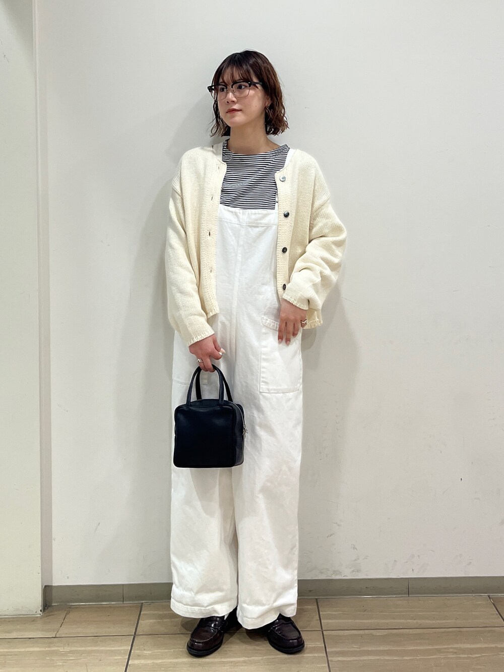 ホワイト系のサロペット/オーバーオール、ホワイト系のカーディガン/ボレロ、ブラック系のTシャツ/カットソーを着用したレディースの冬コーディネートの2枚目の写真