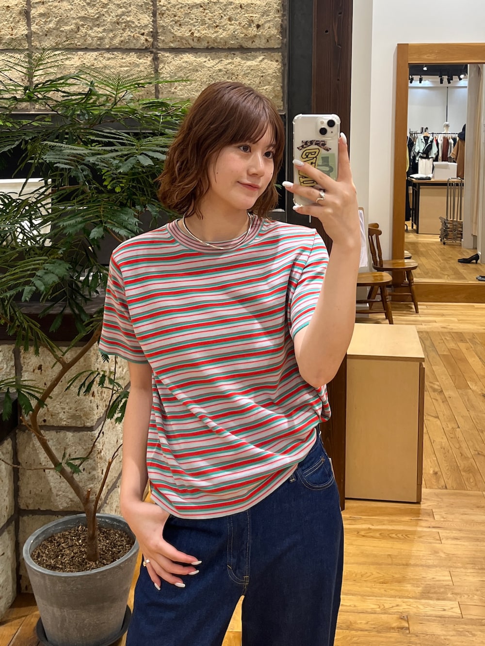 レッド系のTシャツ/カットソー、ブルー系のデニムパンツを着用したレディースの夏コーディネートの2枚目の写真