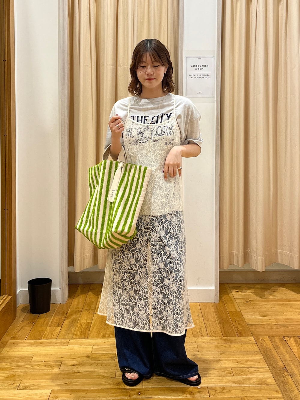 グレー系のTシャツ/カットソー、ホワイト系のワンピース、グリーン系のトートバッグを着用したレディースの春コーディネートの2枚目の写真