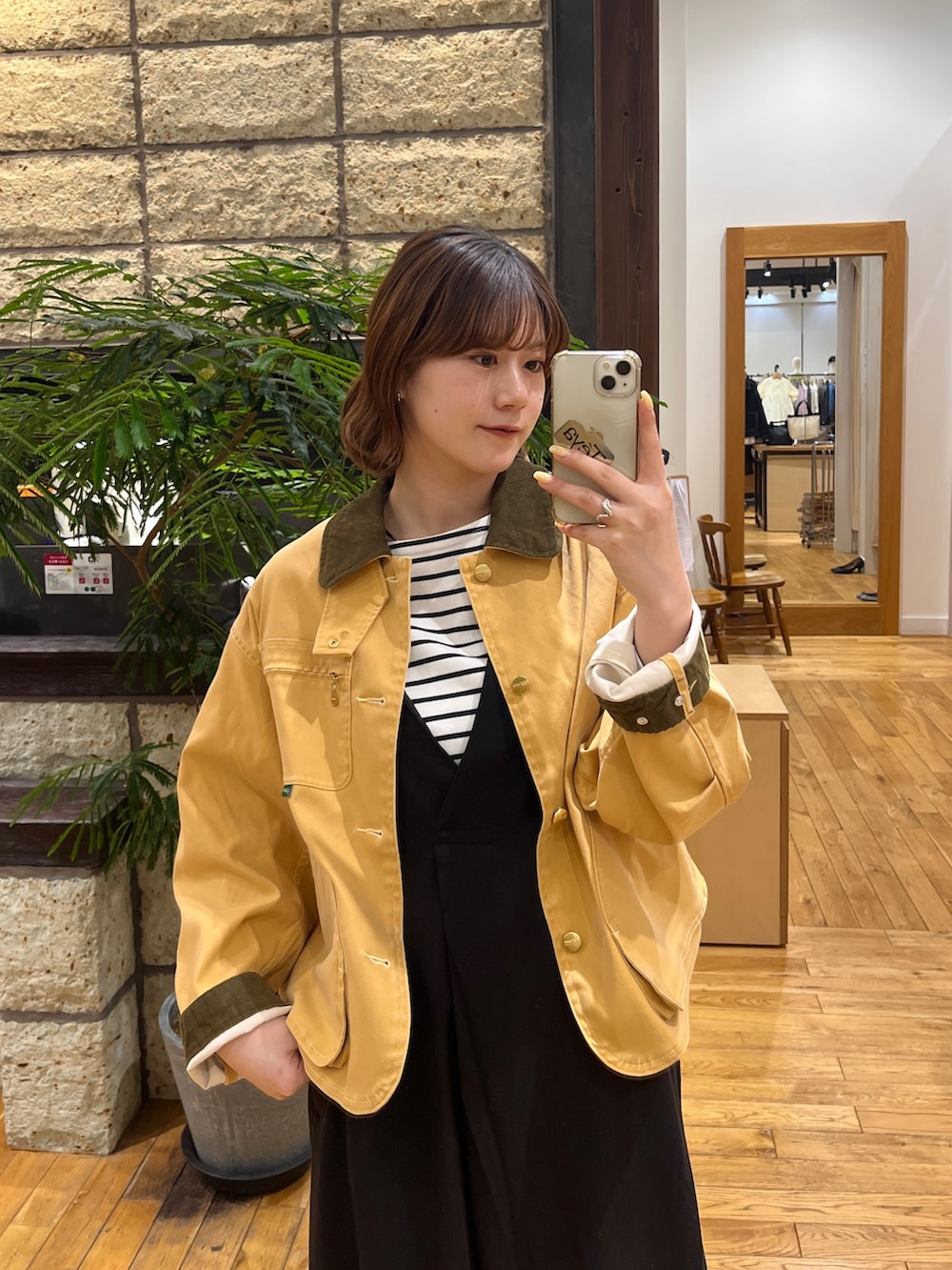 イエロー系のテーラードジャケット、ブラック系のTシャツ/カットソー、ブラック系のワンピースを着用したレディースの春コーディネートの3枚目の写真