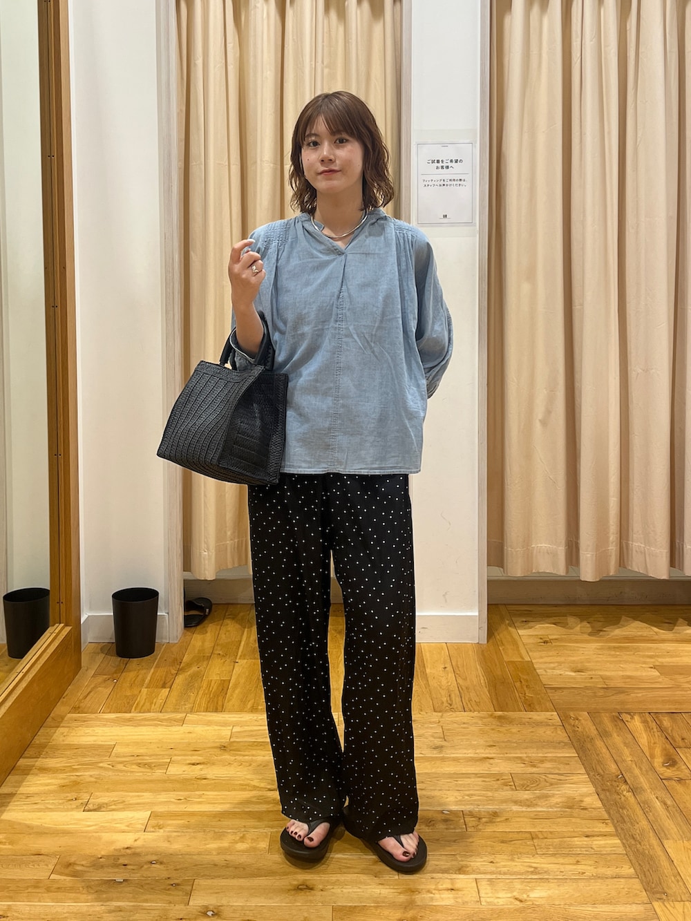 ブルー系のシャツ/ブラウス、ブラック系のハンドバッグ、ブラック系のサンダルを着用したレディースの夏コーディネートの2枚目の写真