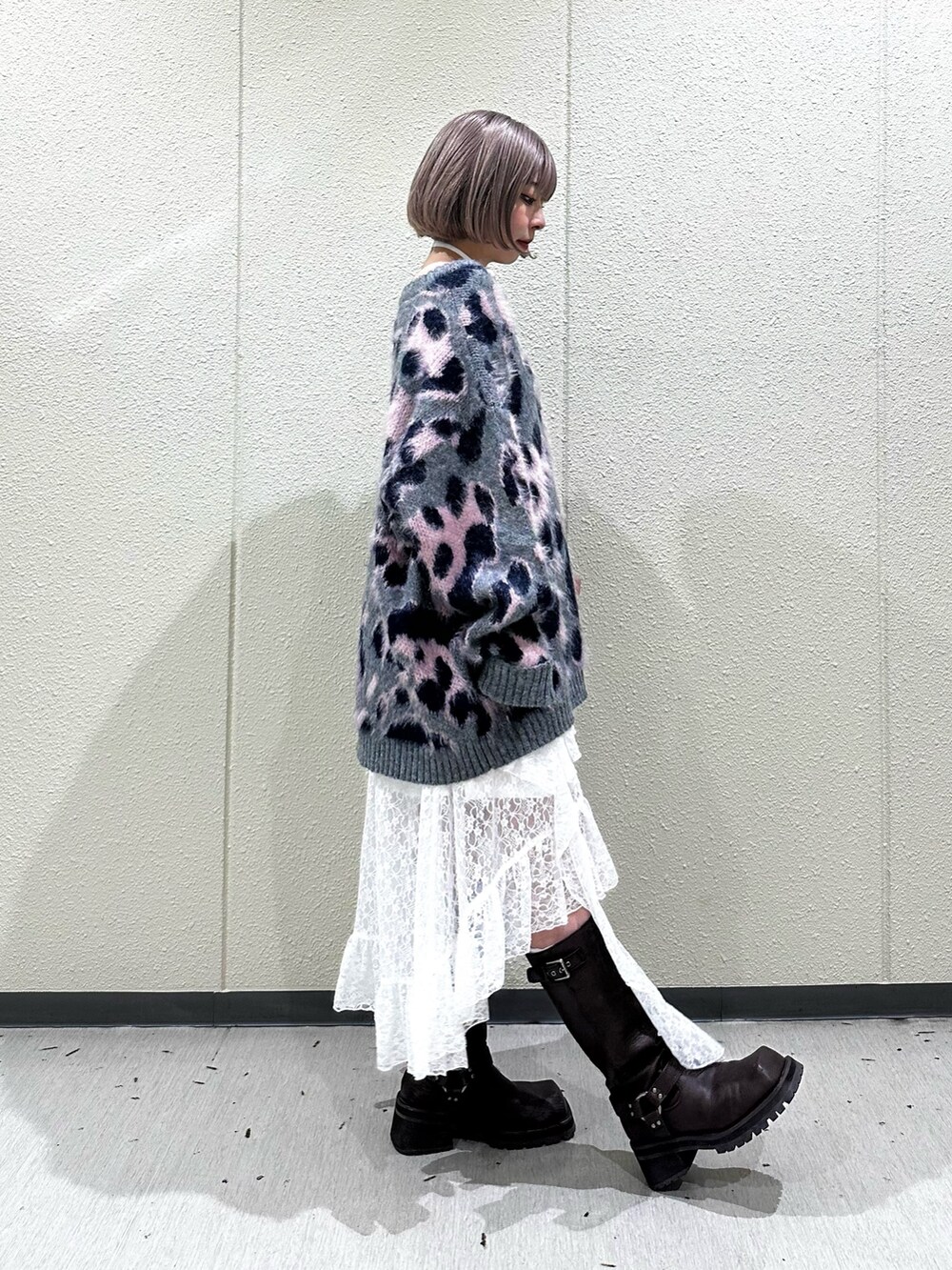 グレー系のニット/セーター、ホワイト系のスカート、ブラウン系のブーツを着用したレディースの秋コーディネートの4枚目の写真