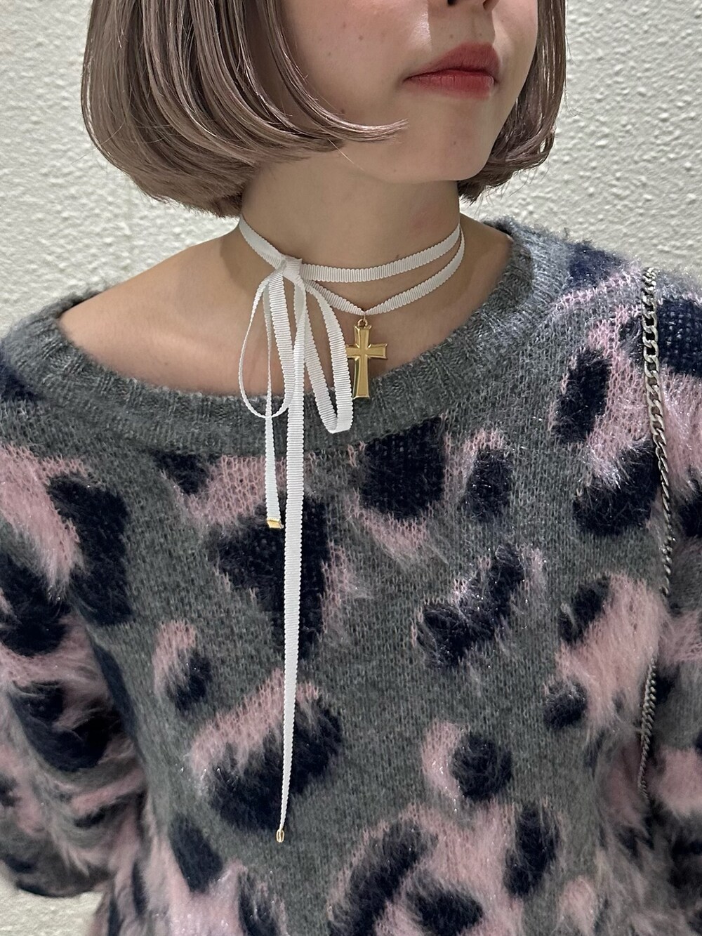 グレー系のニット/セーター、ホワイト系のスカート、ブラウン系のブーツを着用したレディースの秋コーディネートの8枚目の写真