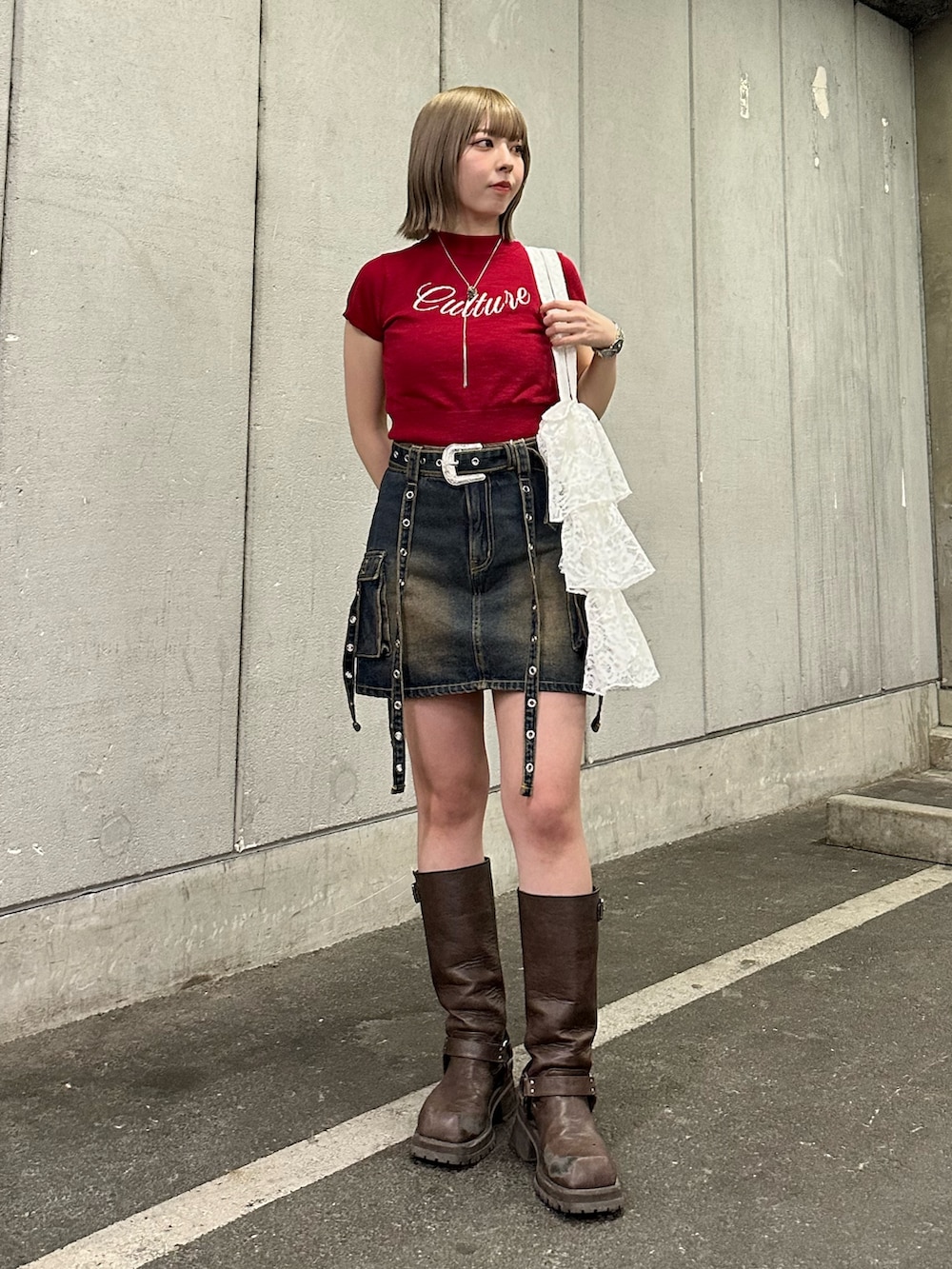 レッド系のニット/セーター、ブルー系のスカート、ブラウン系のブーツを着用したレディースの春コーディネートの4枚目の写真