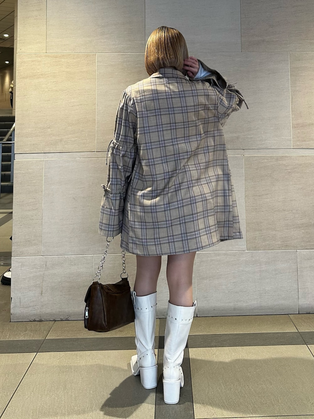 ベージュ系のテーラードジャケット、ベージュ系のスカート、ホワイト系のTシャツ/カットソーを着用したレディースの春コーディネートの5枚目の写真