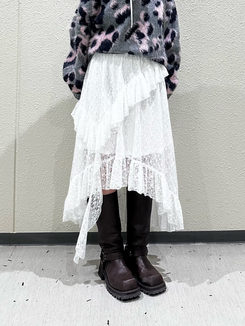 グレー系のニット/セーター、ホワイト系のスカート、ブラウン系のブーツを着用したレディースの秋コーディネートの5枚目の写真