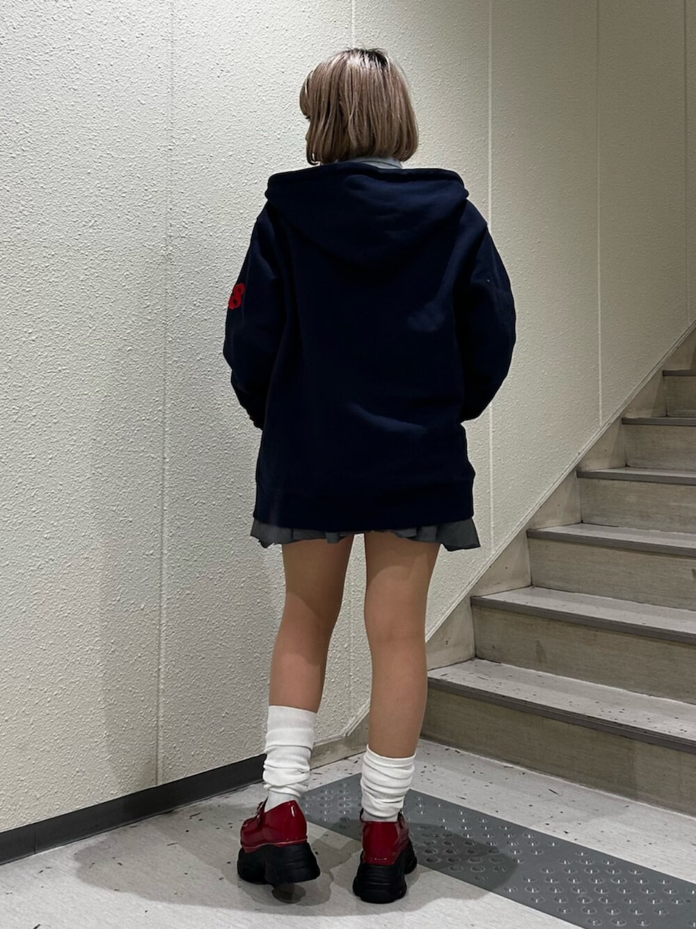 グレー系のスカート、ブルー系のシャツ/ブラウス、レッド系のローファーを着用したレディースの冬コーディネートの3枚目の写真