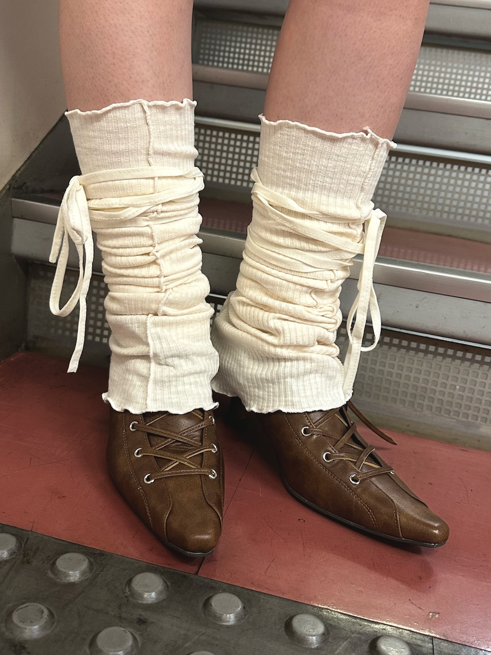 ブラック系のワンピース、ブラウン系のハンドバッグ、ブラウン系のパンプスを着用したレディースの春コーディネートの8枚目の写真