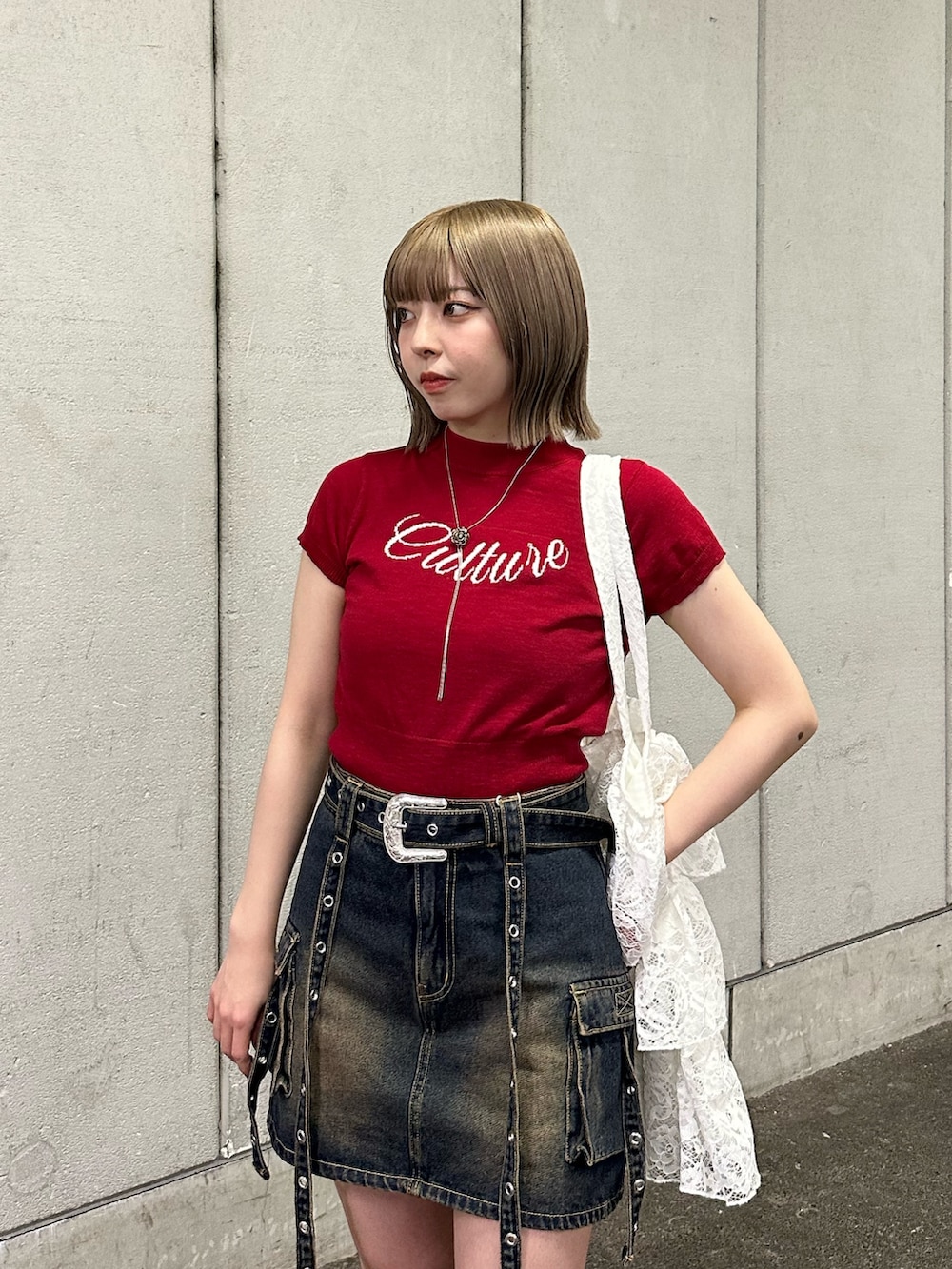 レッド系のニット/セーター、ブルー系のスカート、ブラウン系のブーツを着用したレディースの春コーディネートの7枚目の写真