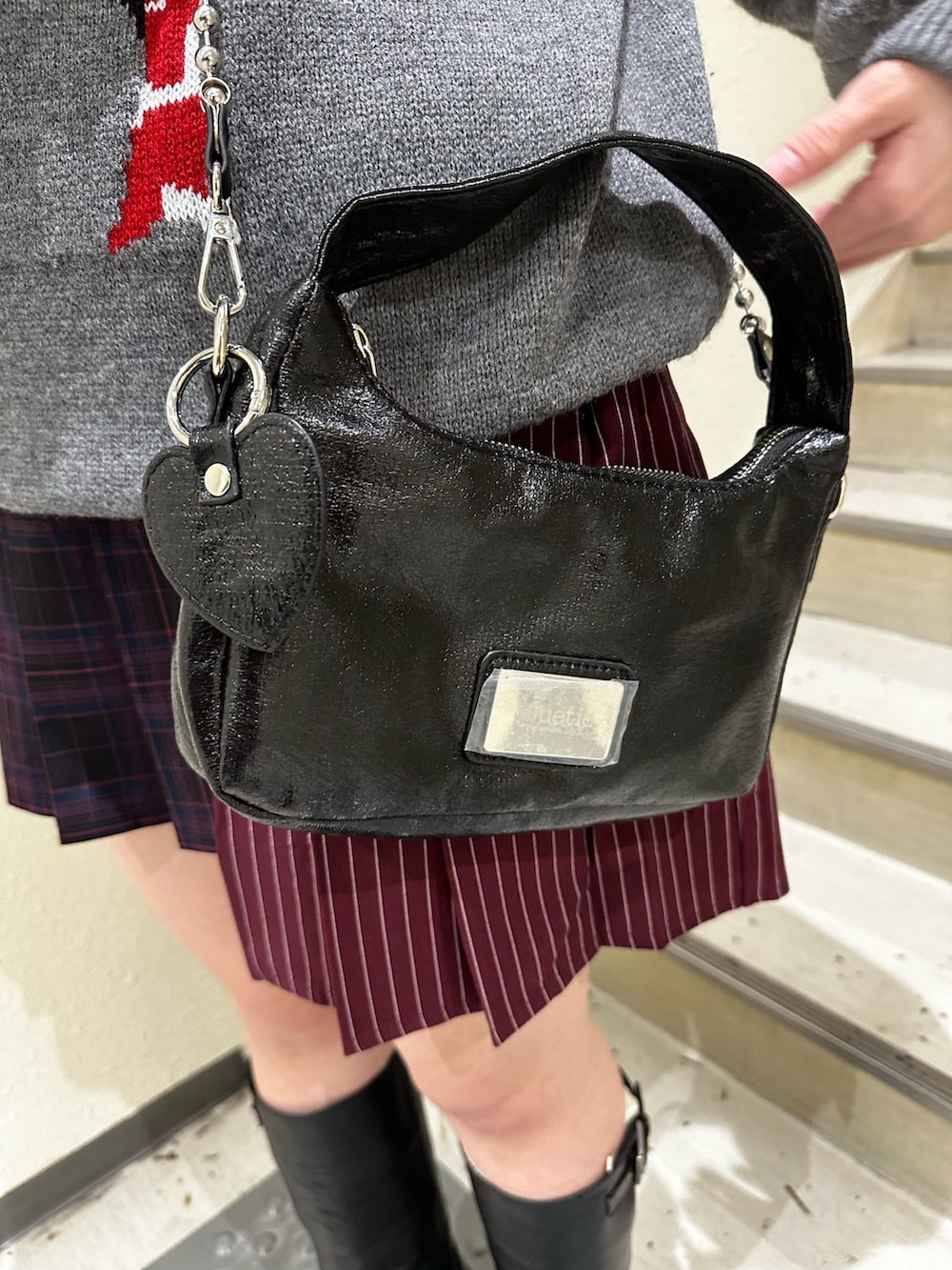 グレー系のニット/セーター、レッド系のスカート、ブラック系のブーツを着用したレディースの冬コーディネートの8枚目の写真