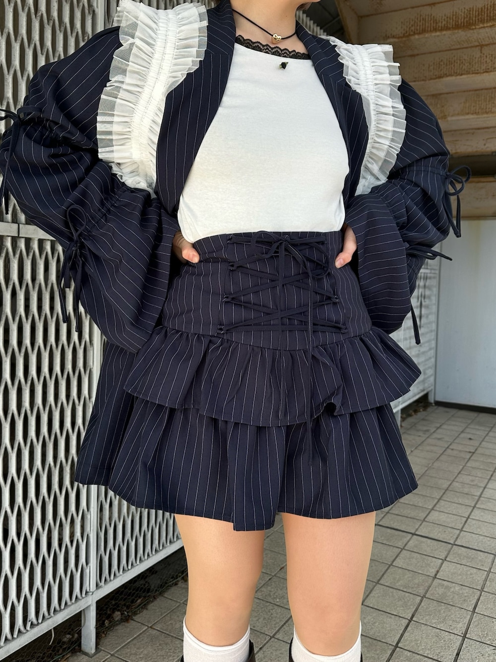 ブルー系のテーラードジャケット、ホワイト系のTシャツ/カットソー、ブラウン系のブーツを着用したレディースの冬コーディネートの10枚目の写真