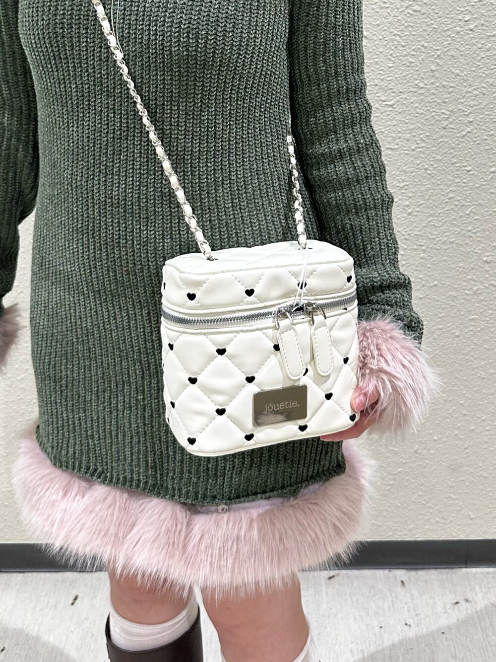 グリーン系のワンピース、ホワイト系のショルダーバッグ、ブラウン系のブーツを着用したレディースの秋コーディネートの7枚目の写真