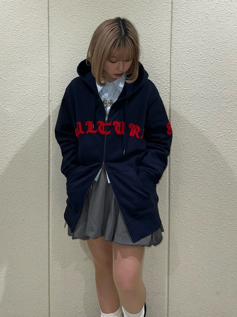 グレー系のスカート、ブルー系のシャツ/ブラウス、レッド系のローファーを着用したレディースの冬コーディネートの6枚目の写真