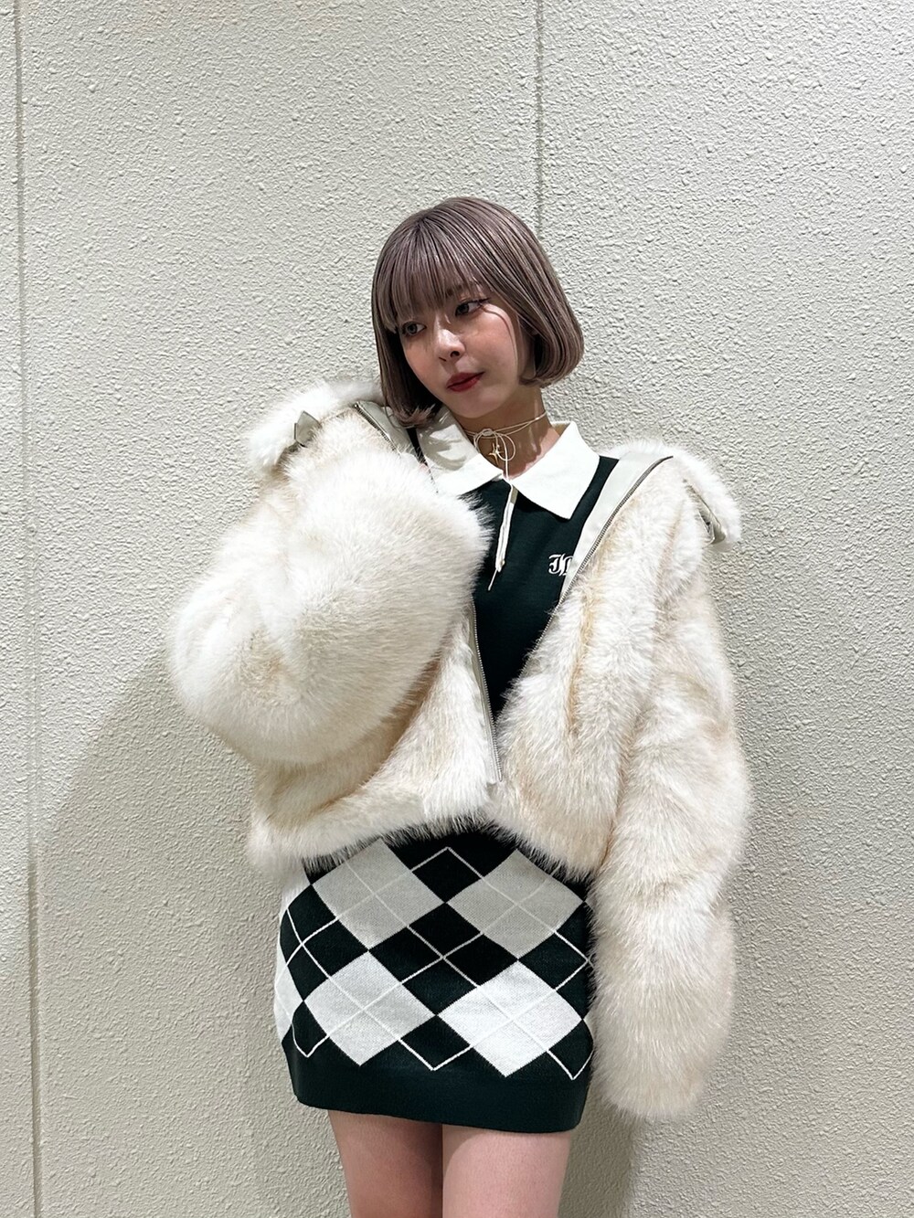 グリーン系のワンピース、ブラウン系のブーツ、ホワイト系のその他アウターを着用したレディースの秋コーディネートの6枚目の写真