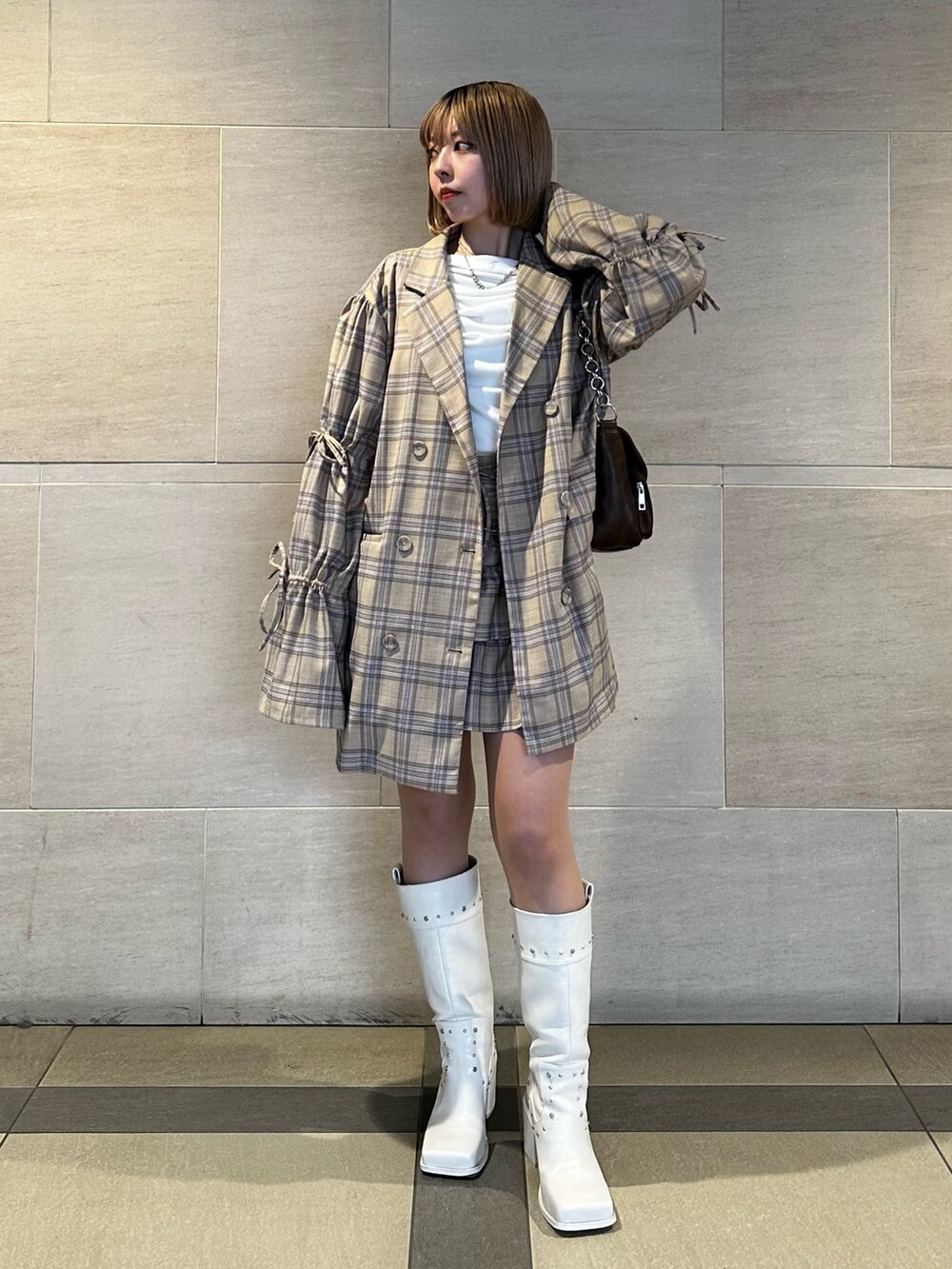 ベージュ系のテーラードジャケット、ベージュ系のスカート、ホワイト系のTシャツ/カットソーを着用したレディースの春コーディネートの3枚目の写真