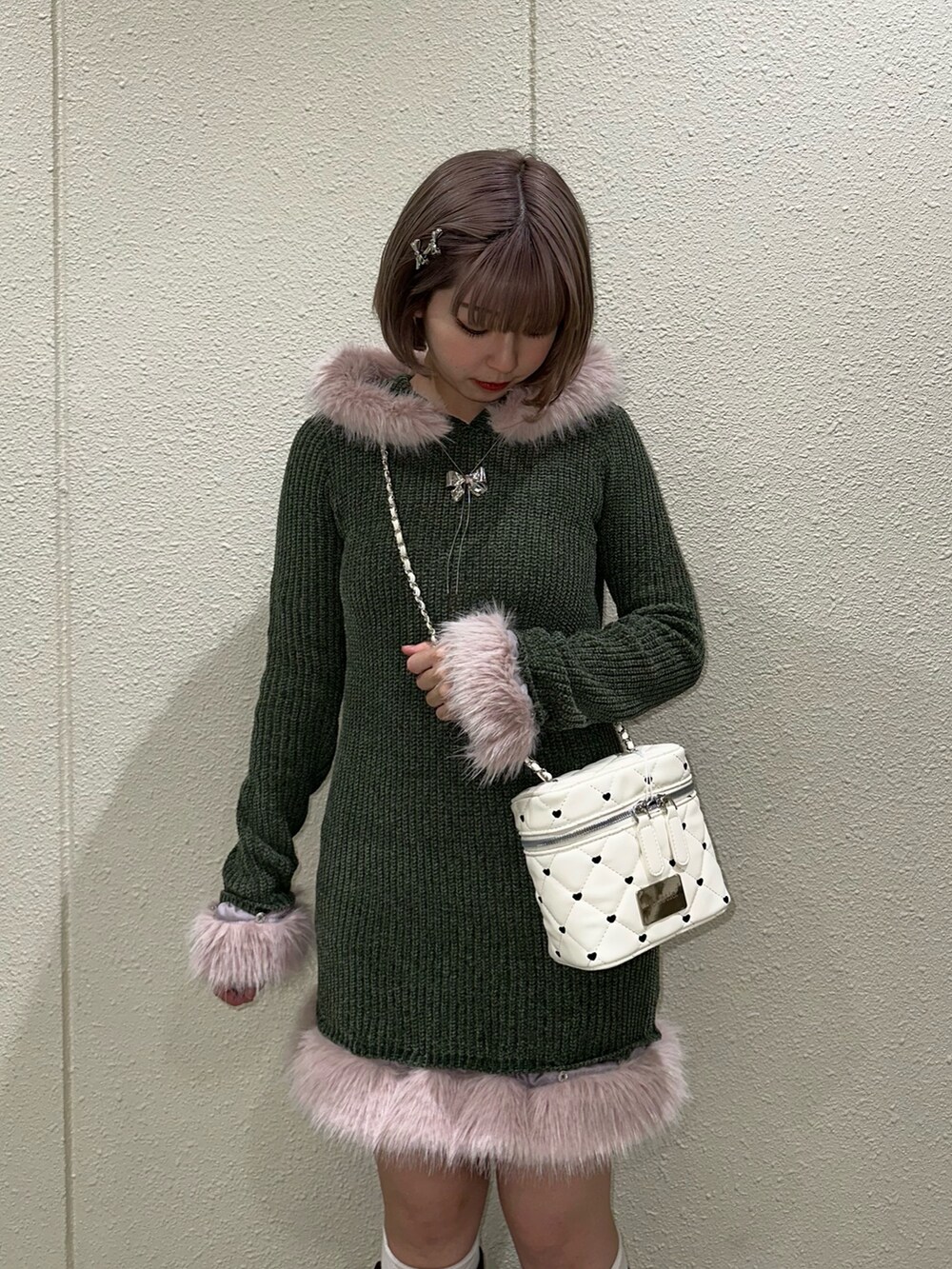 グリーン系のワンピース、ホワイト系のショルダーバッグ、ブラウン系のブーツを着用したレディースの秋コーディネートの4枚目の写真