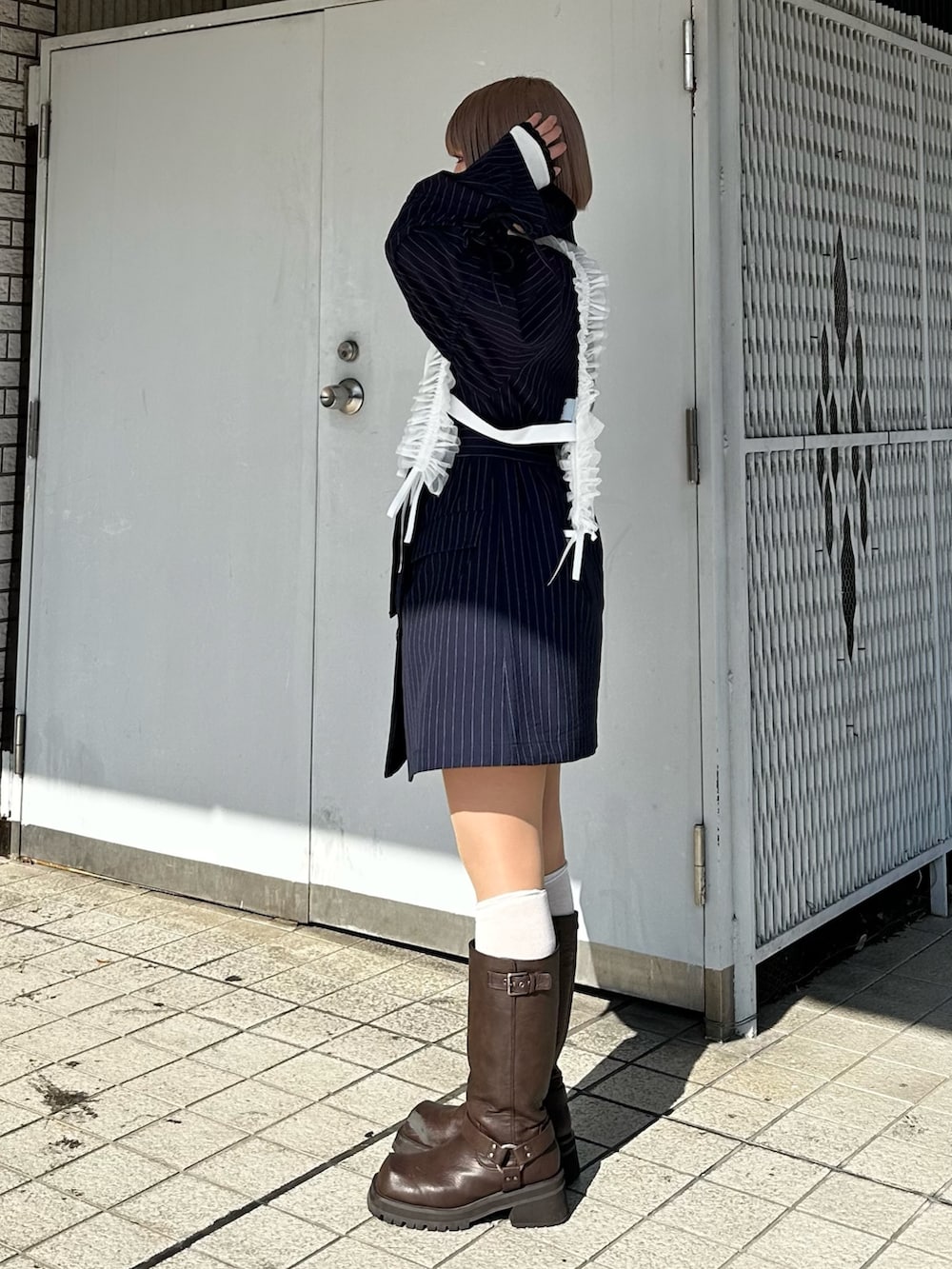 ブルー系のテーラードジャケット、ホワイト系のTシャツ/カットソー、ブラウン系のブーツを着用したレディースの冬コーディネートの5枚目の写真