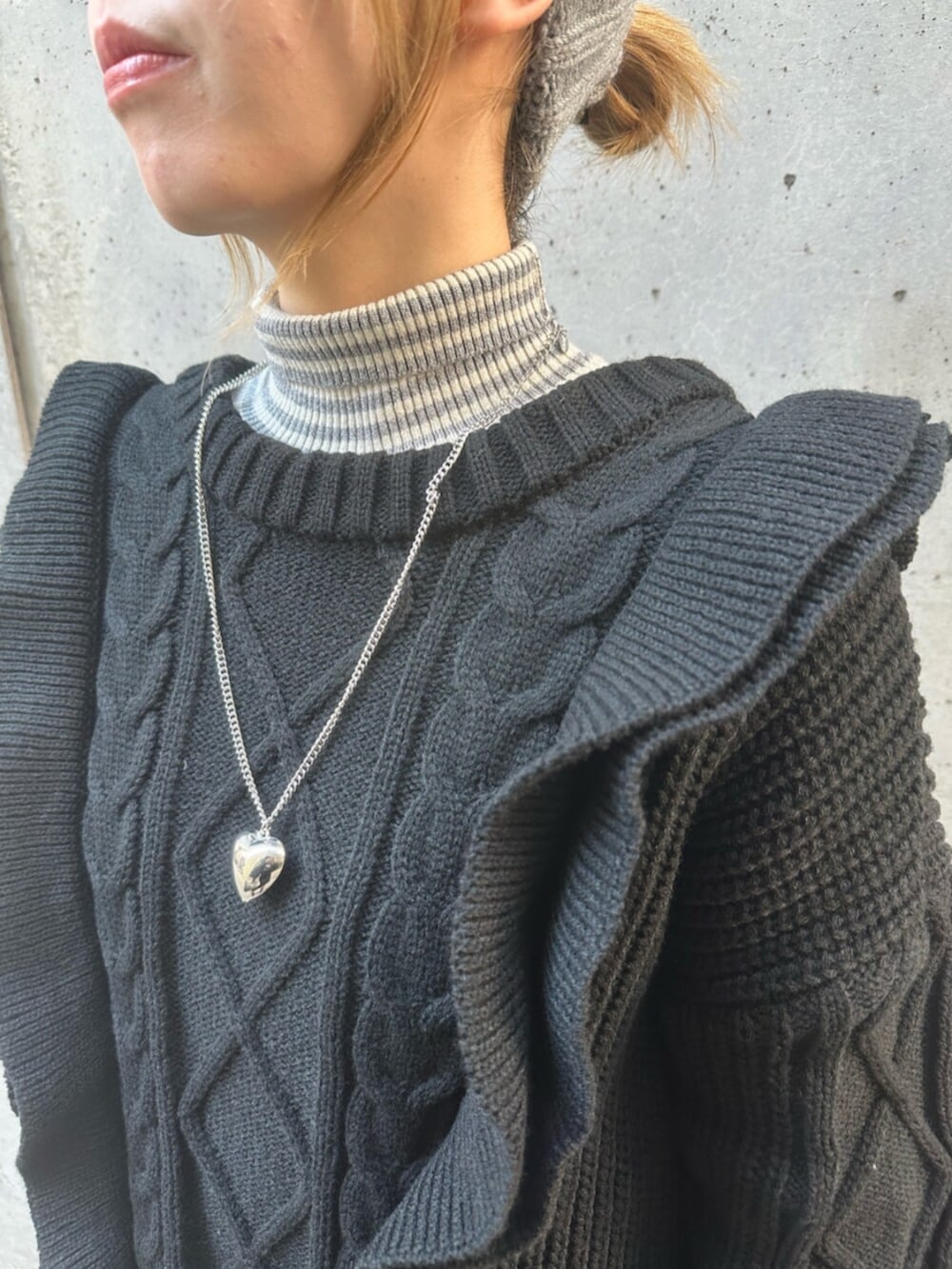 ブラック系のスニーカー、ブラック系のニット/セーター、レッド系のハンドバッグを着用したレディースの冬コーディネートの9枚目の写真