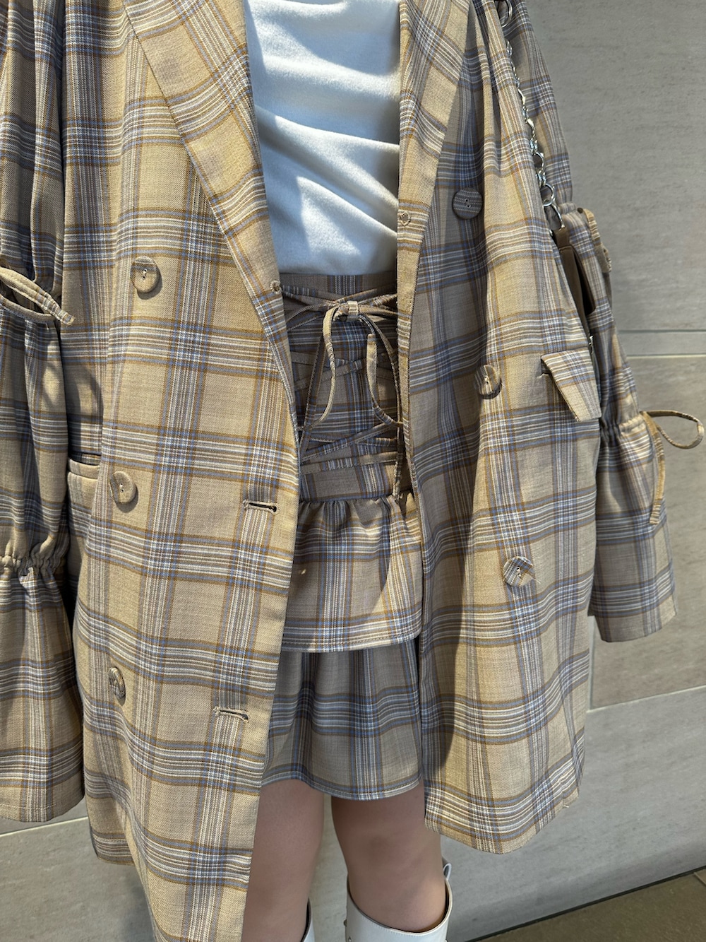 ベージュ系のテーラードジャケット、ベージュ系のスカート、ホワイト系のTシャツ/カットソーを着用したレディースの春コーディネートの9枚目の写真