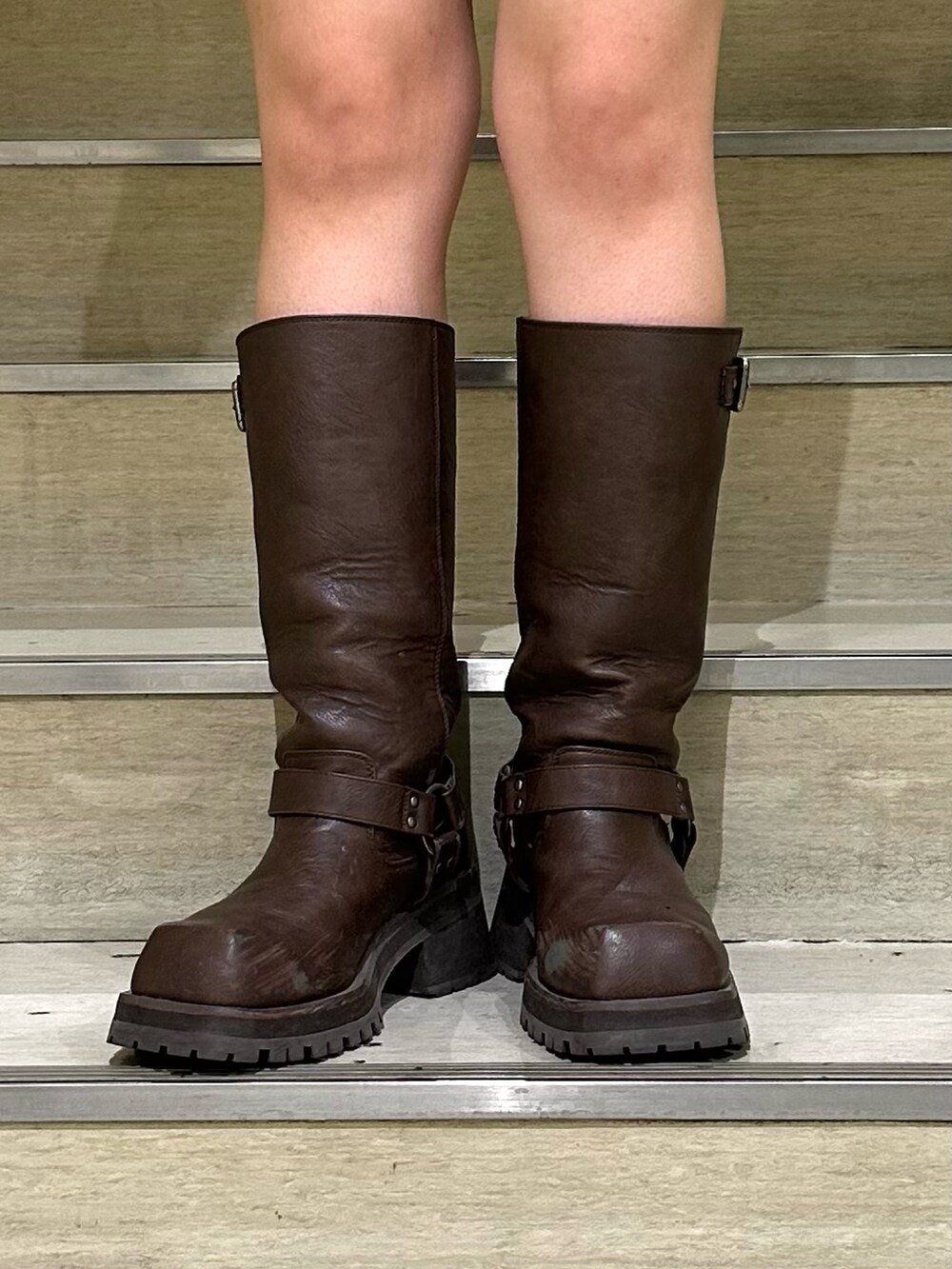 グリーン系のワンピース、ブラウン系のブーツ、ホワイト系のその他アウターを着用したレディースの秋コーディネートの8枚目の写真