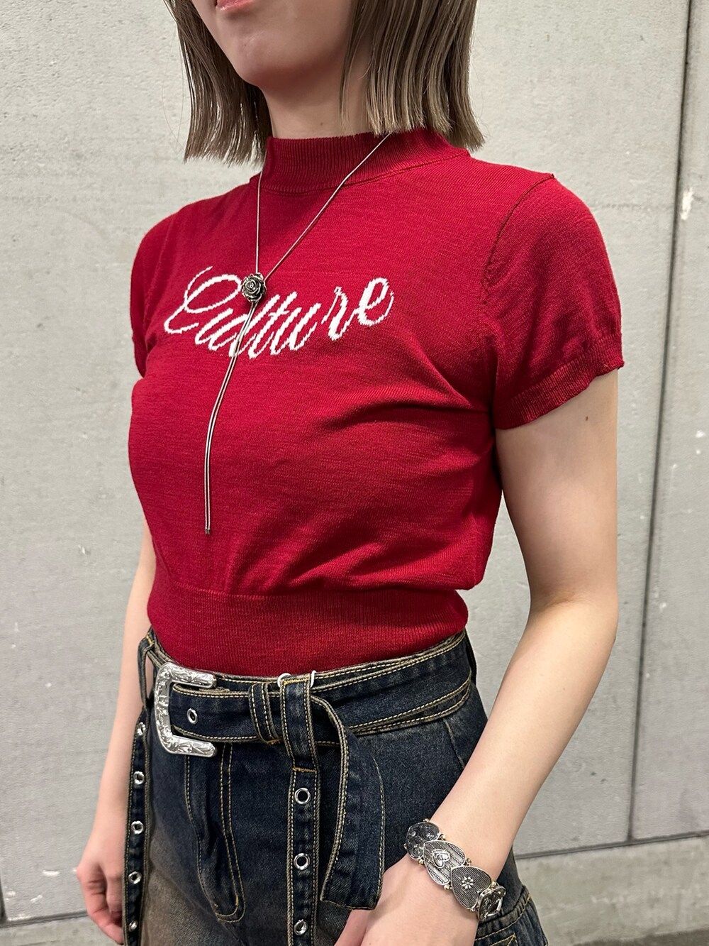 レッド系のニット/セーター、ブルー系のスカート、ブラウン系のブーツを着用したレディースの春コーディネートの8枚目の写真