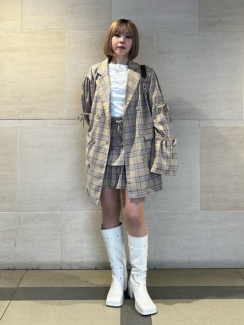 ベージュ系のテーラードジャケット、ベージュ系のスカート、ホワイト系のTシャツ/カットソーを着用したレディースの春コーディネートの2枚目の写真