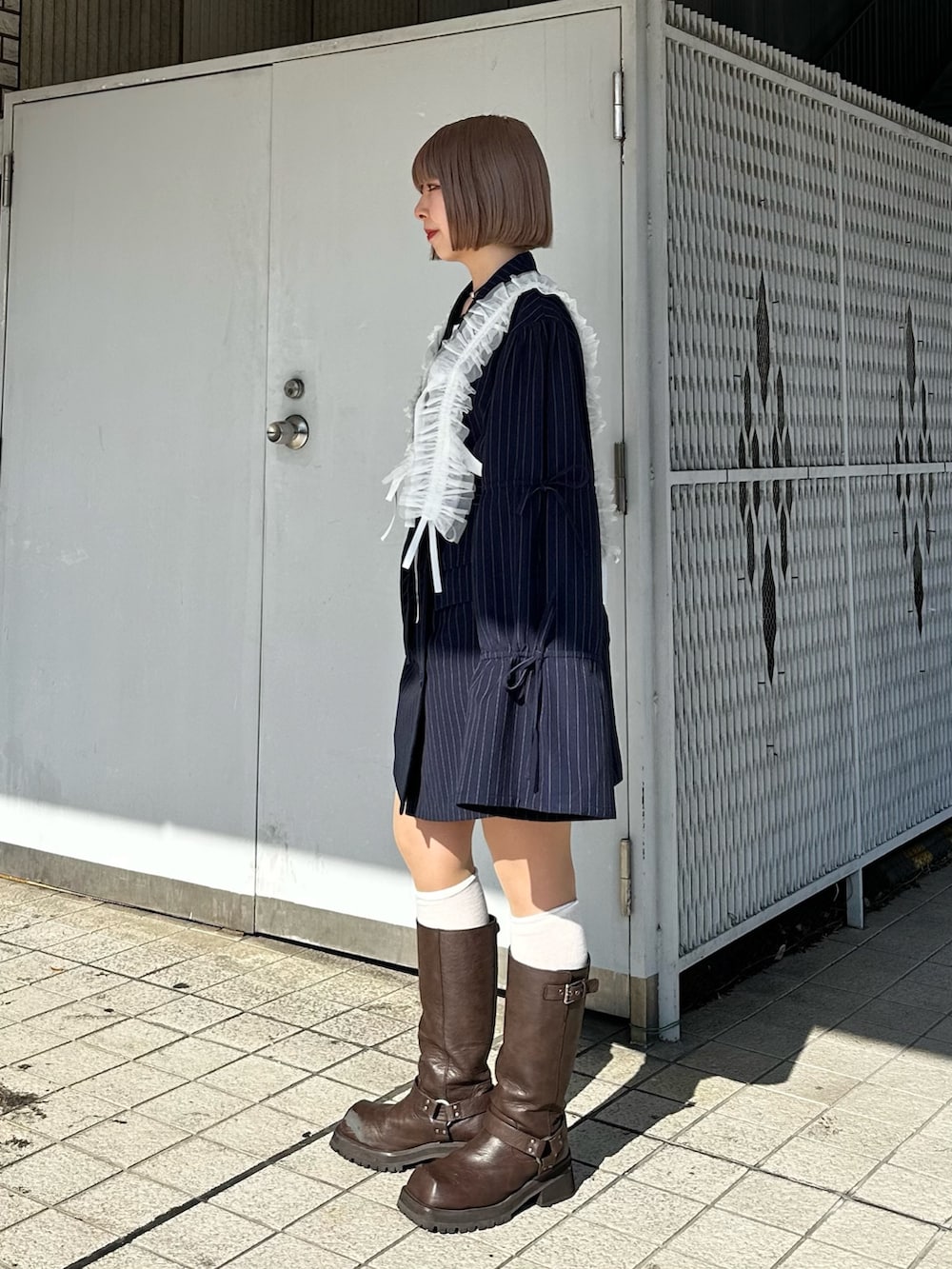 ブルー系のテーラードジャケット、ホワイト系のTシャツ/カットソー、ブラウン系のブーツを着用したレディースの冬コーディネートの4枚目の写真